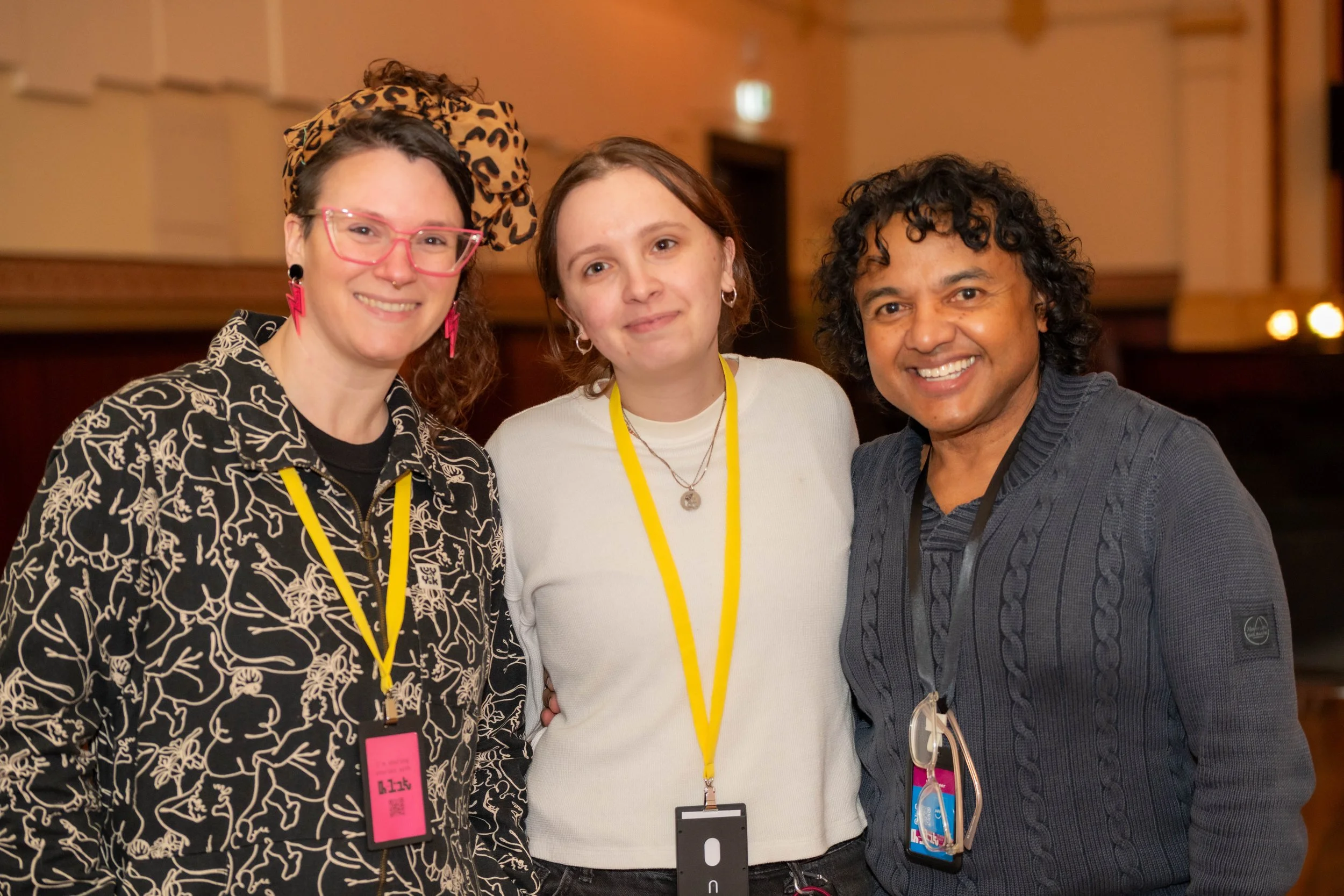 Three humans smile at the camera.