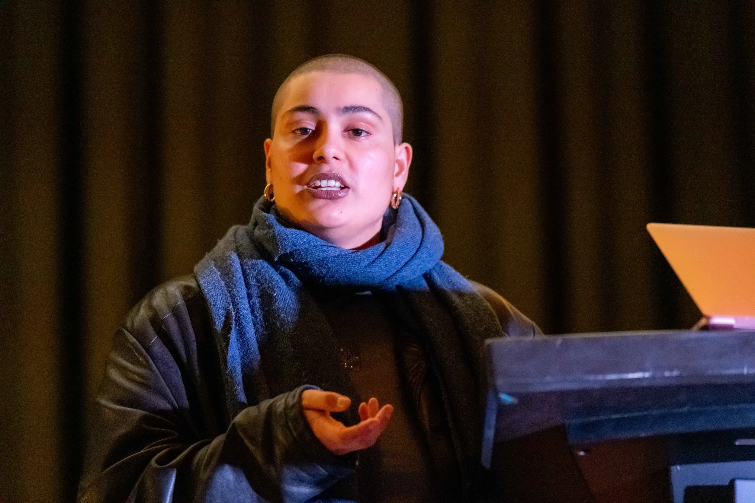 Dr Eboy Muller stands behind a lecturn and speaks into a microphone.