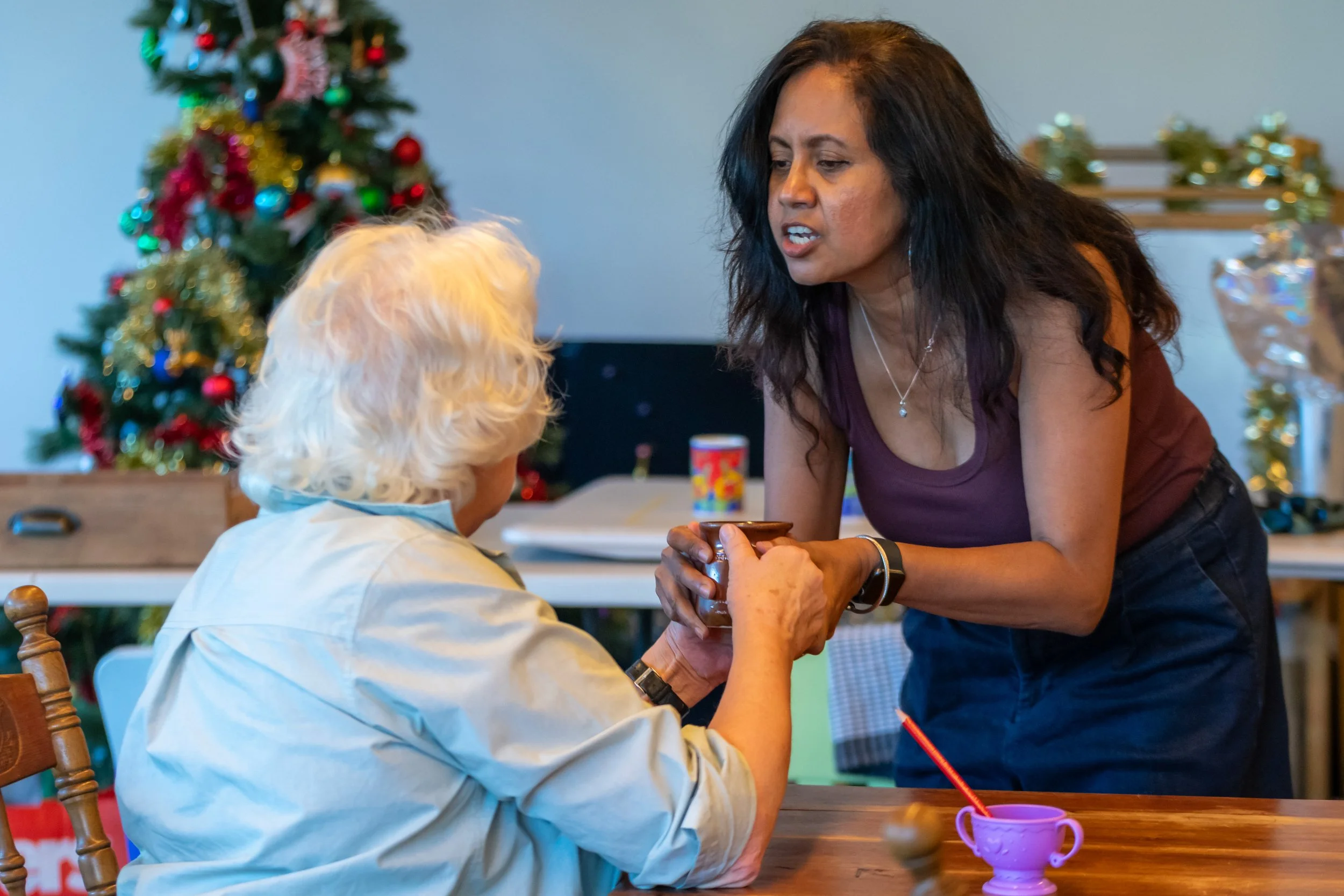 Two humans fight over a mug. One is standing over the other.