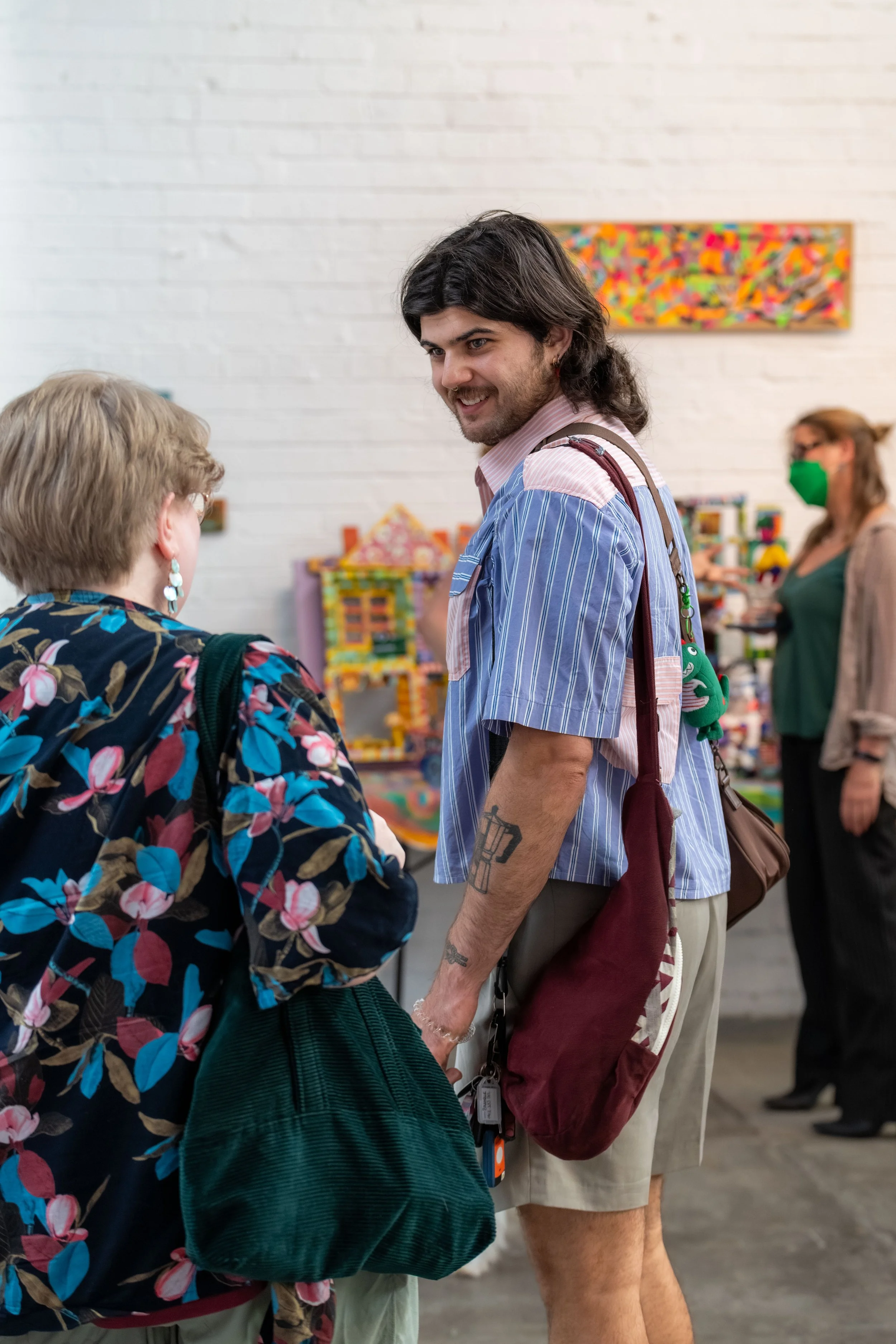 Two humans stand talking with each other.
