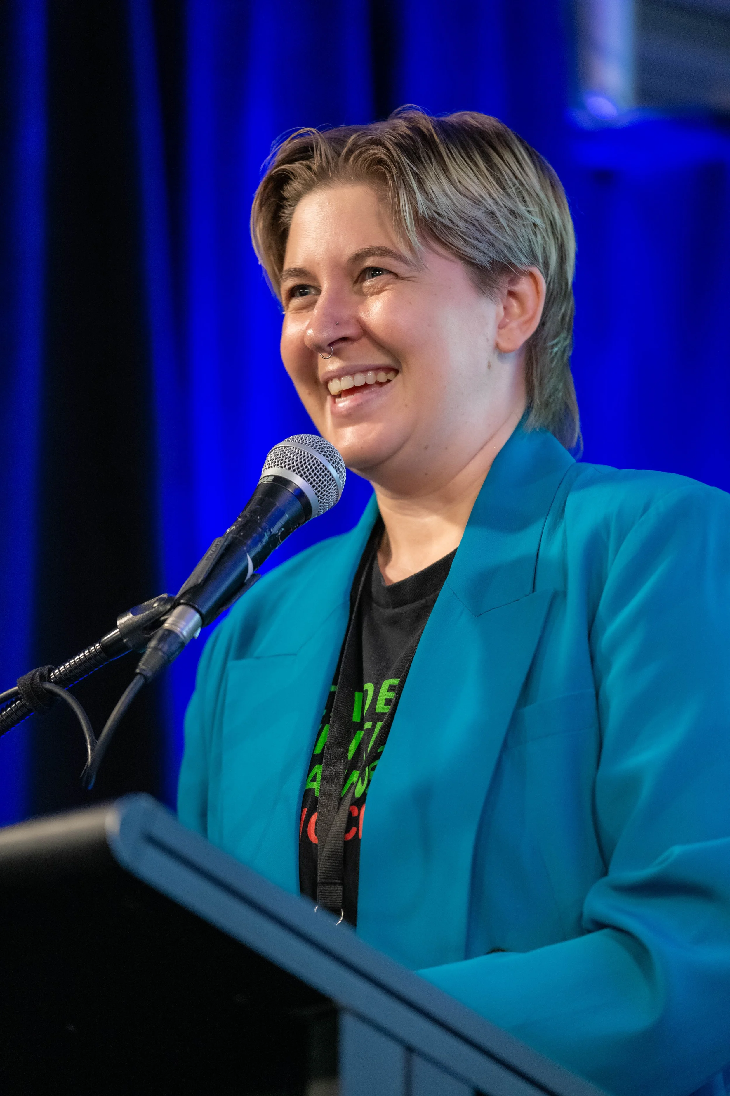 Eli Sutherland at a lectern, smiling.