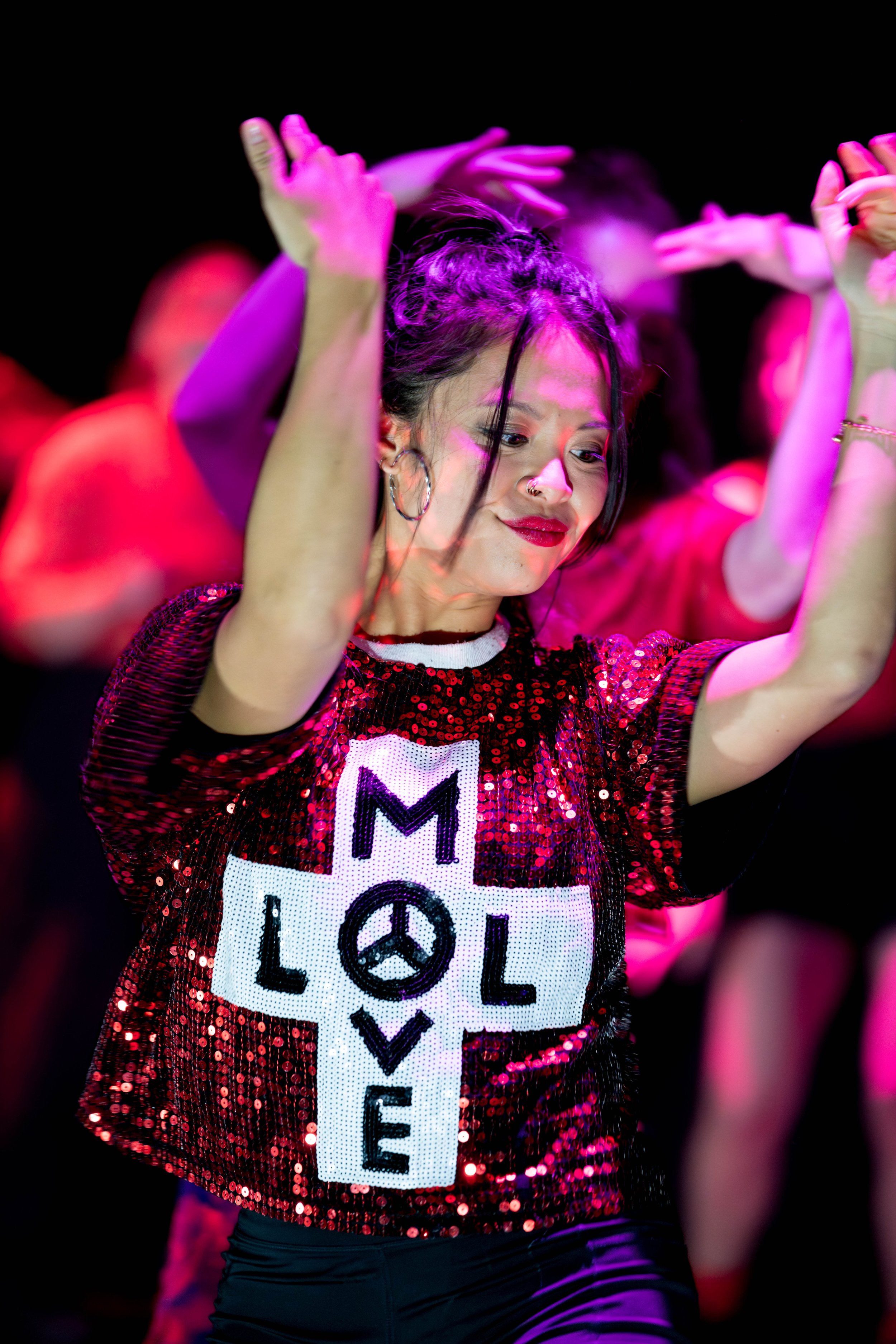 A dancer wears a red sparkly top with Move, LOL on it.