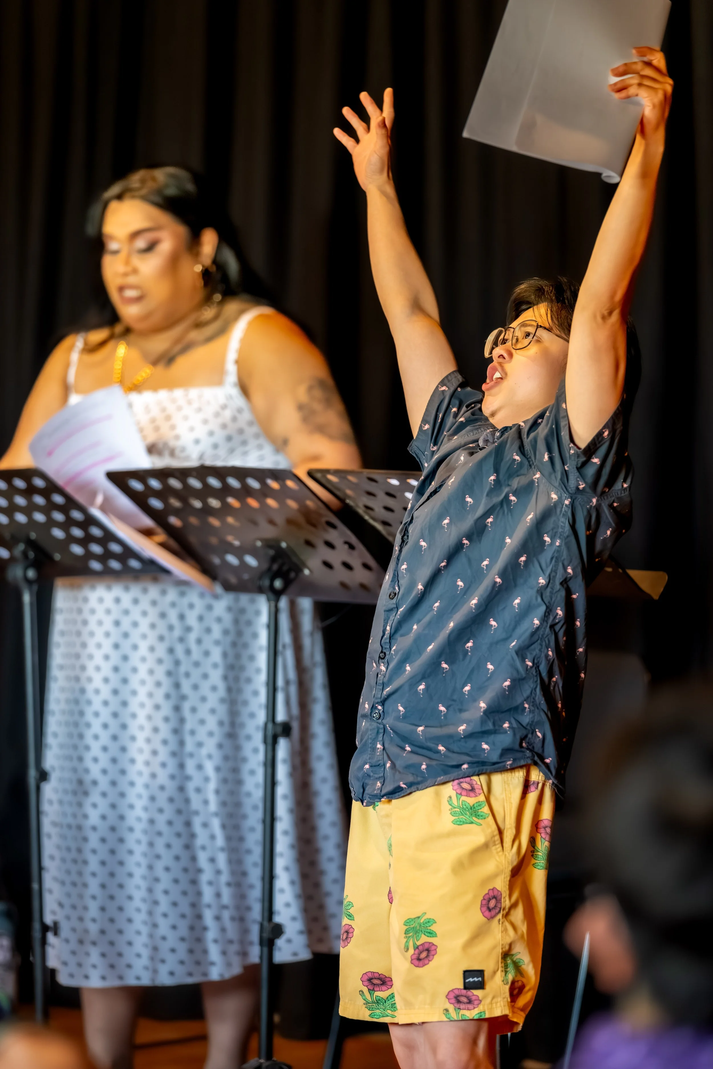 Two humans, one raises their hands above their head.