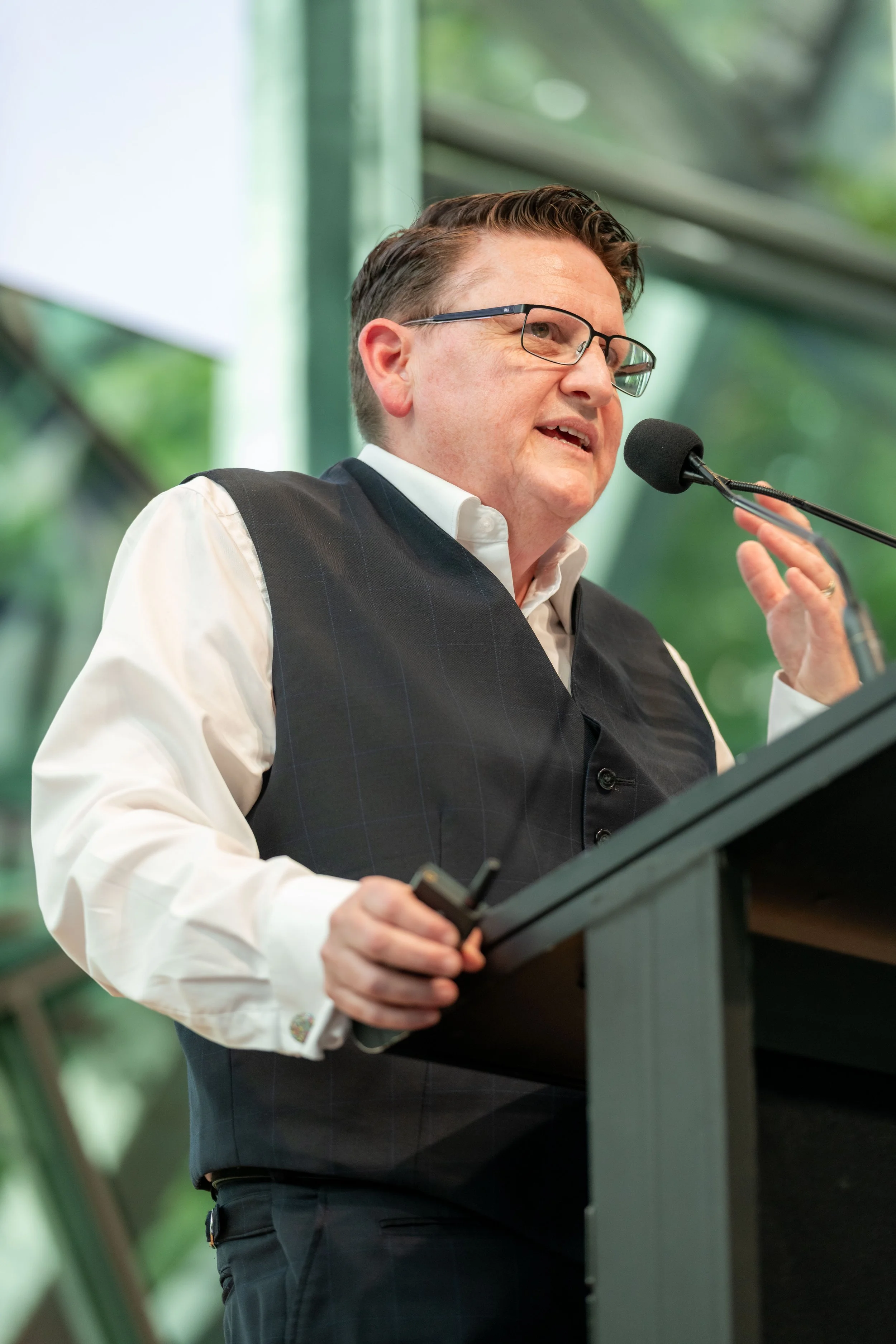 Commissioner Ro Allen speaks into a microphone and gesticulates with a hand.