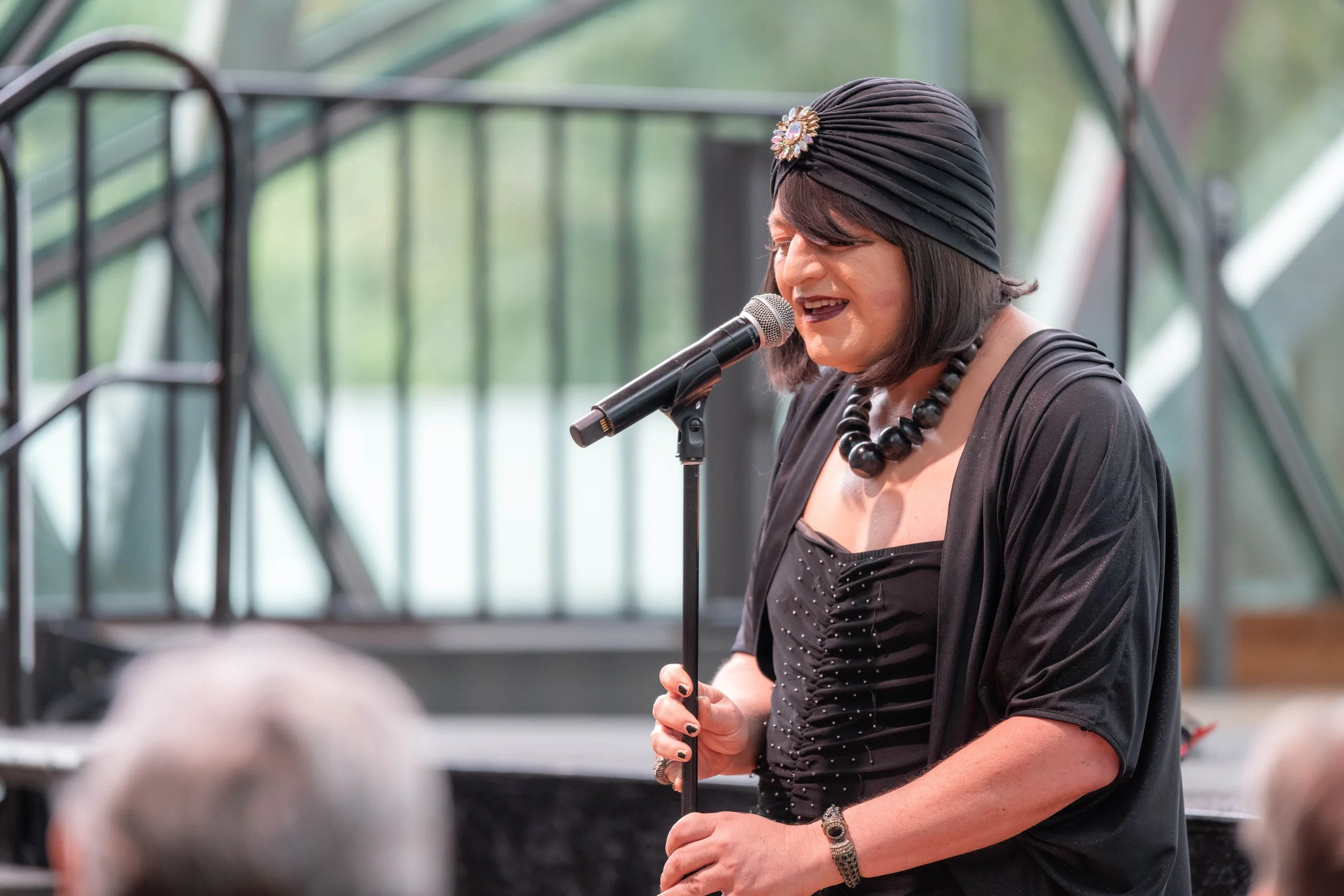 Tina Del Twist sings into a microphone.