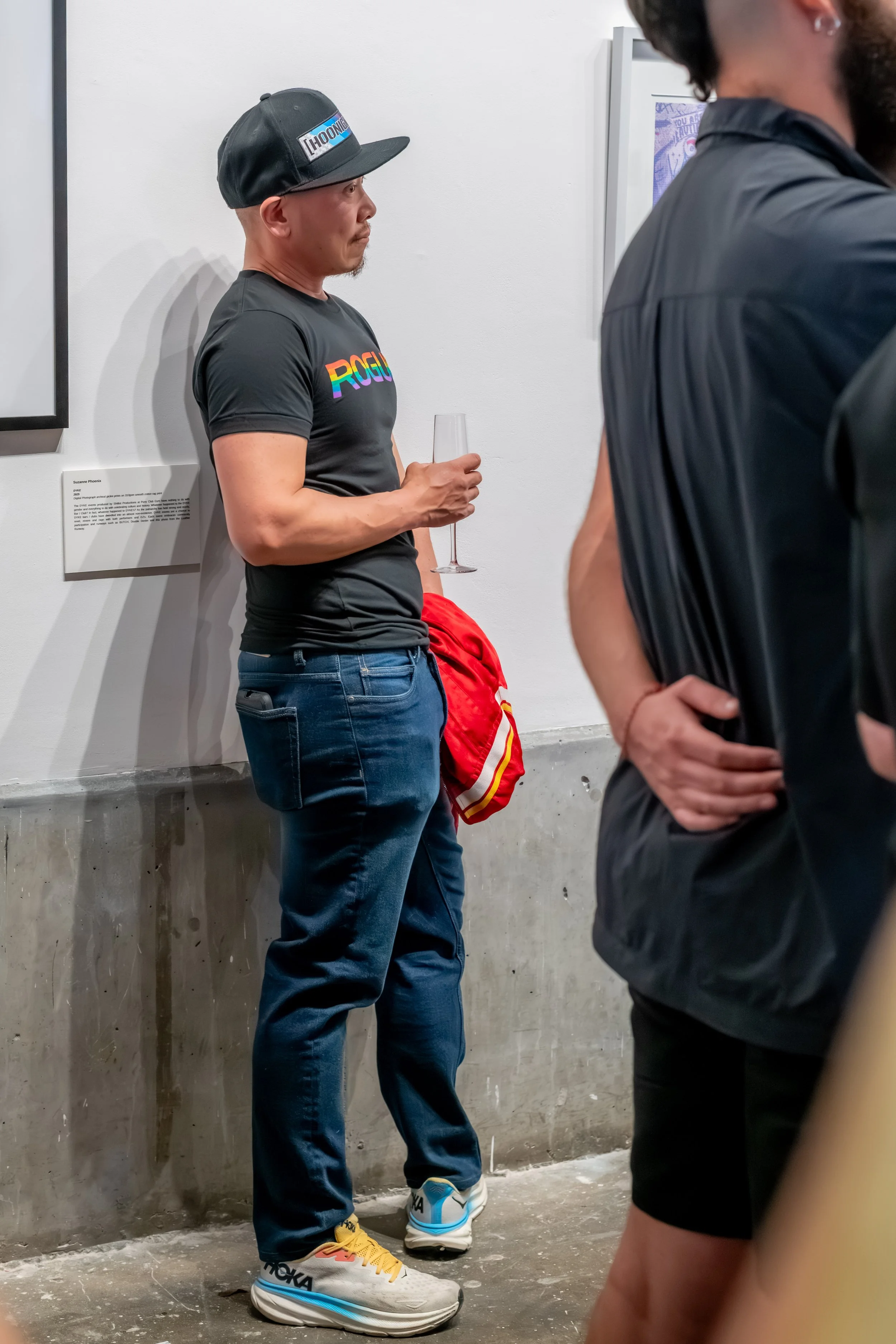 A human in a cap leans against the wall.