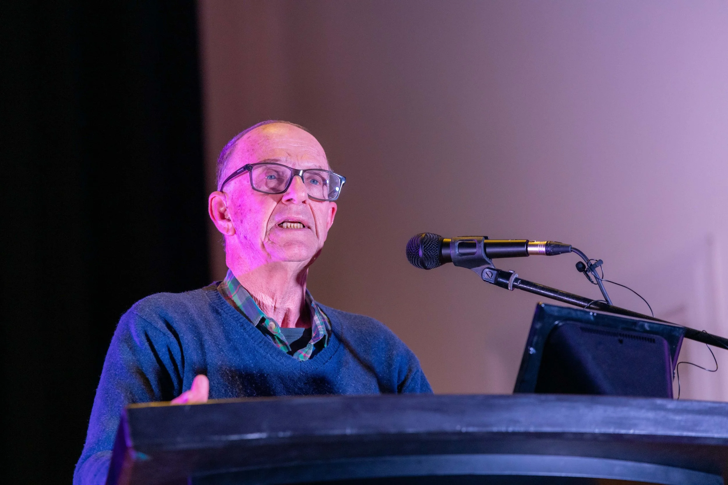 Dennis Altman speaks into a microphone.