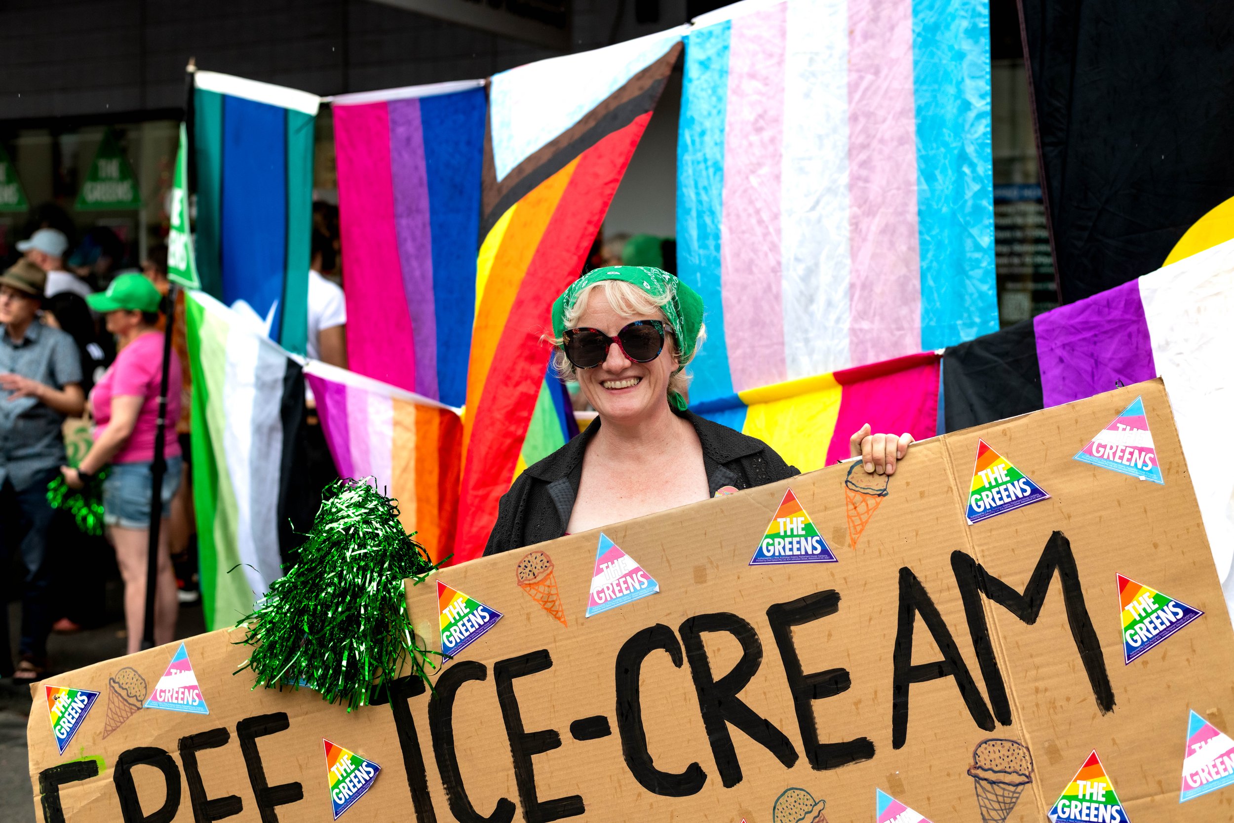 Human from the Greens political party holding up a sign for free ice-cream.