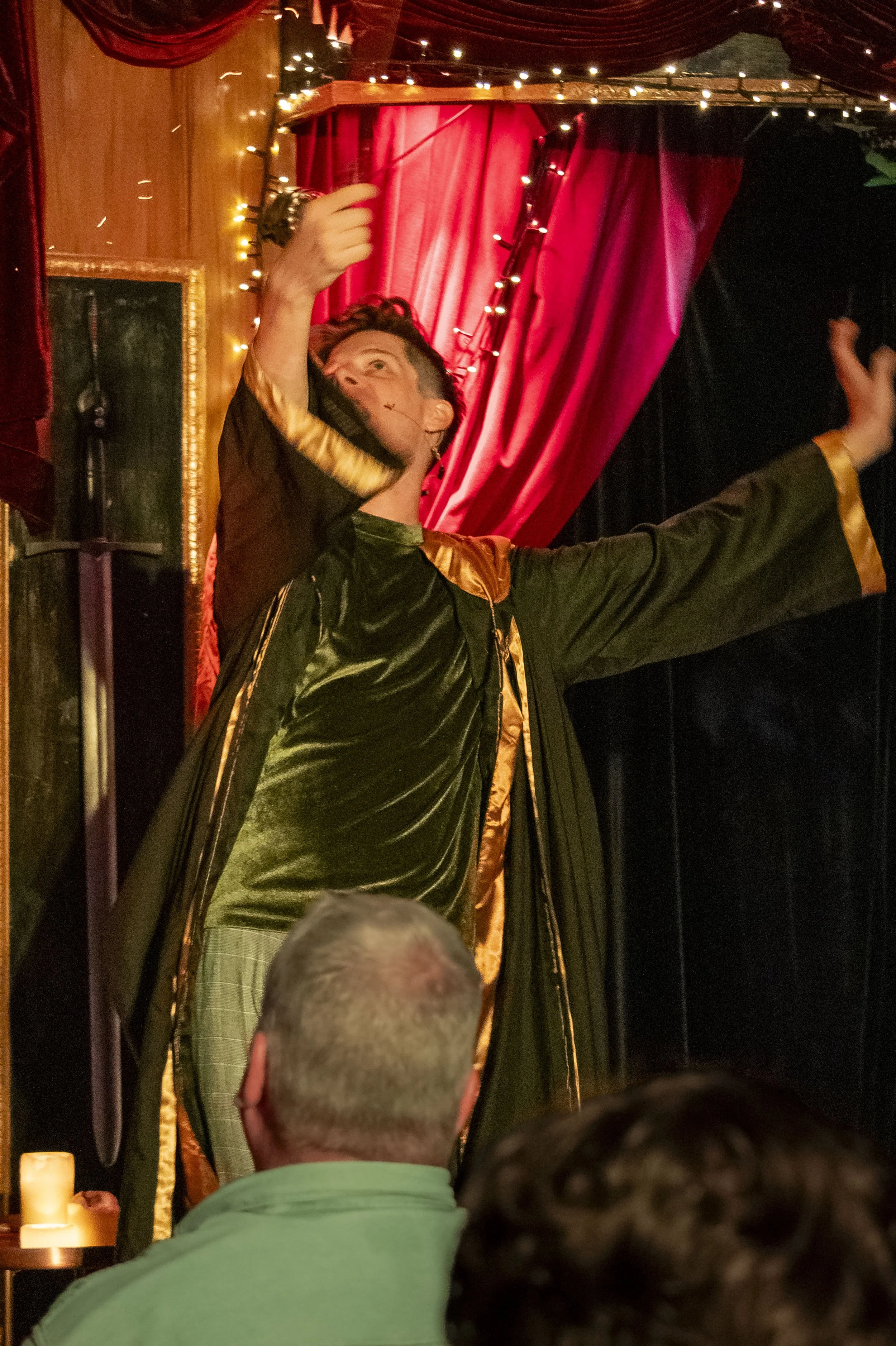 Dirk wears his cloak and waves a wand.