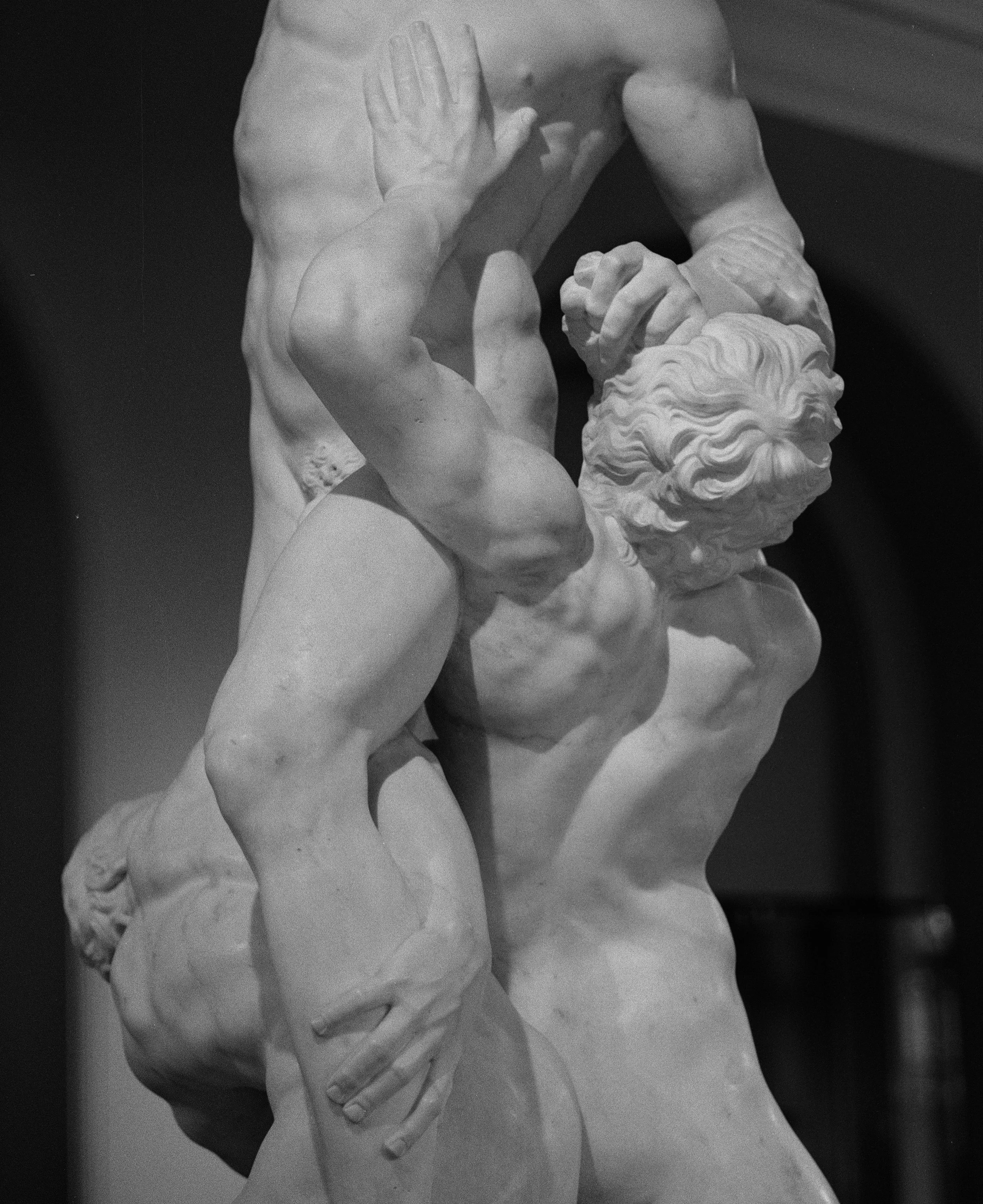 A black and white photograph of the sculpture 'Laocoön and His Sons,' depicting Laocoön and his sons in a struggle with a serpent, showcasing detailed muscles and tense expressions.