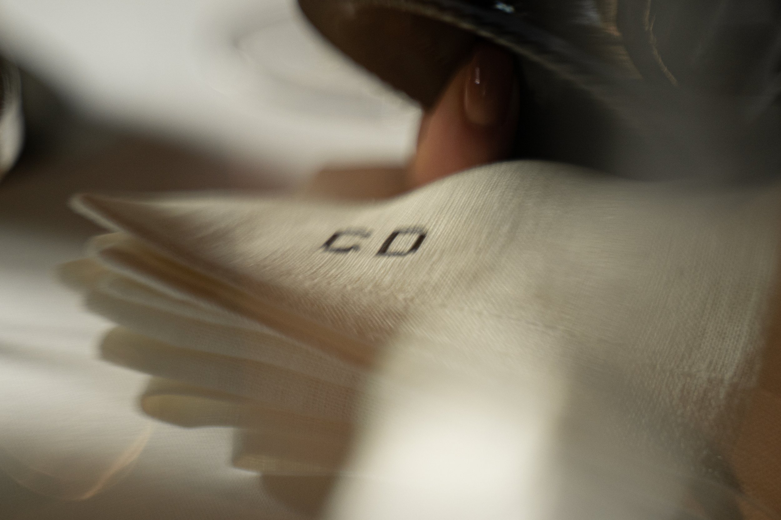 Close-up of a hand holding a beige fabric with black text.
