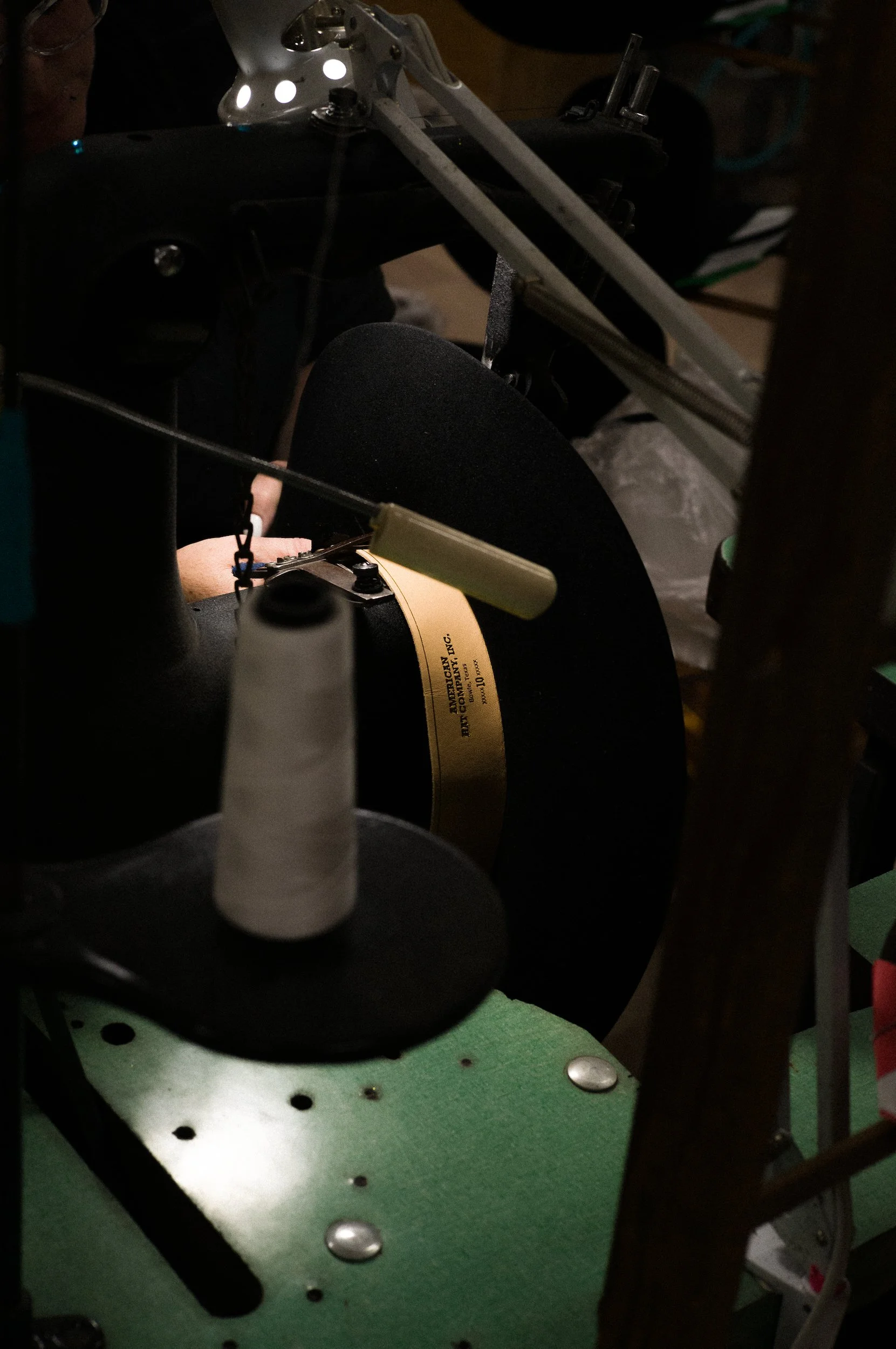 A close up of a hat maker at American Hat Company sewing the inner lining of a Cowboy hat
