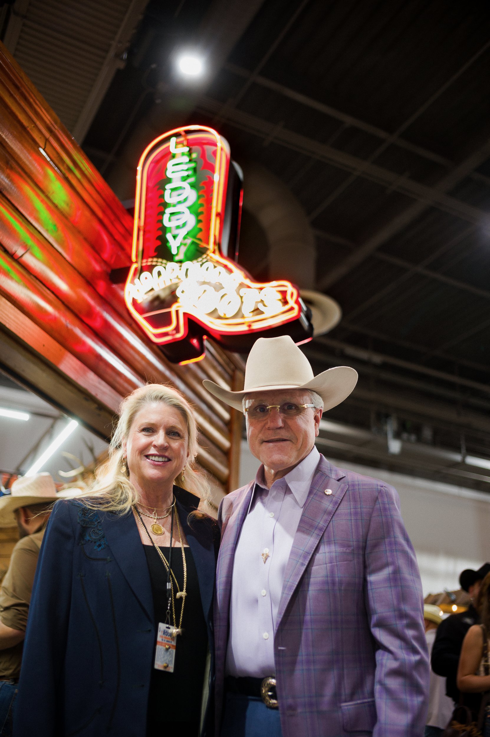 Portrait of Franklin Wilson, owner of ML Leddys, and his wife, with a neon sign in the background. 
