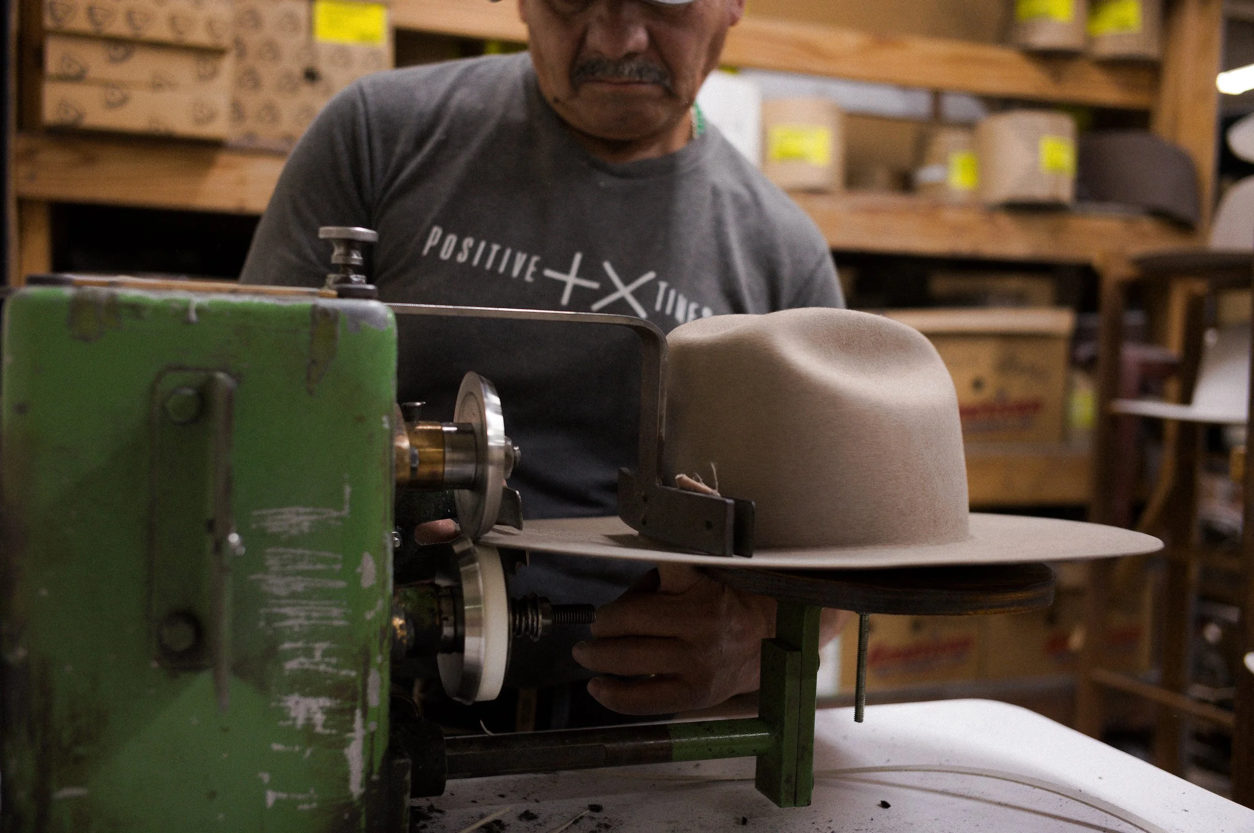 A person working on triming of the brim of an american cowboy hat brim