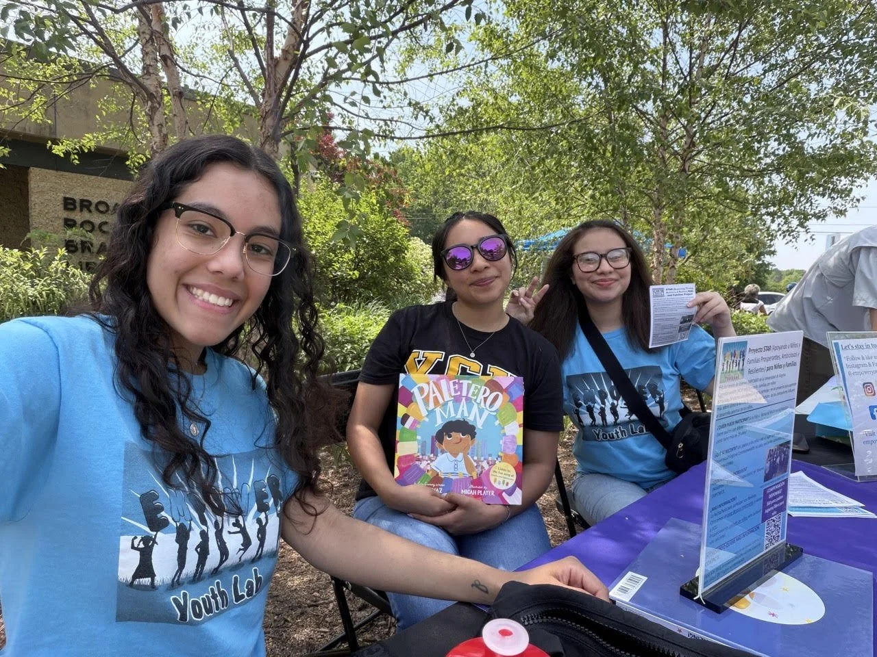 Jules, Regina, and Stephanie talk to families at the library at the Dia de los Niños event