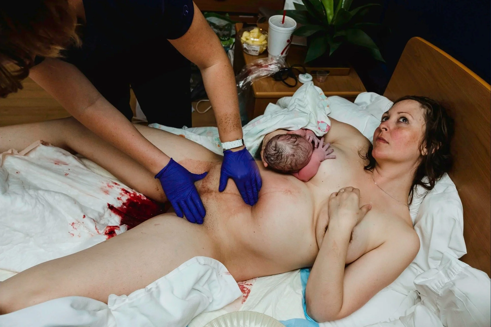As a mom of three I know exactly what is happening in this moment and it is NOT comfortable.
And yet. Look at her face.
After a water birth, with her baby nursing for the first time and her placenta already earthside, she is somewhere completely unre