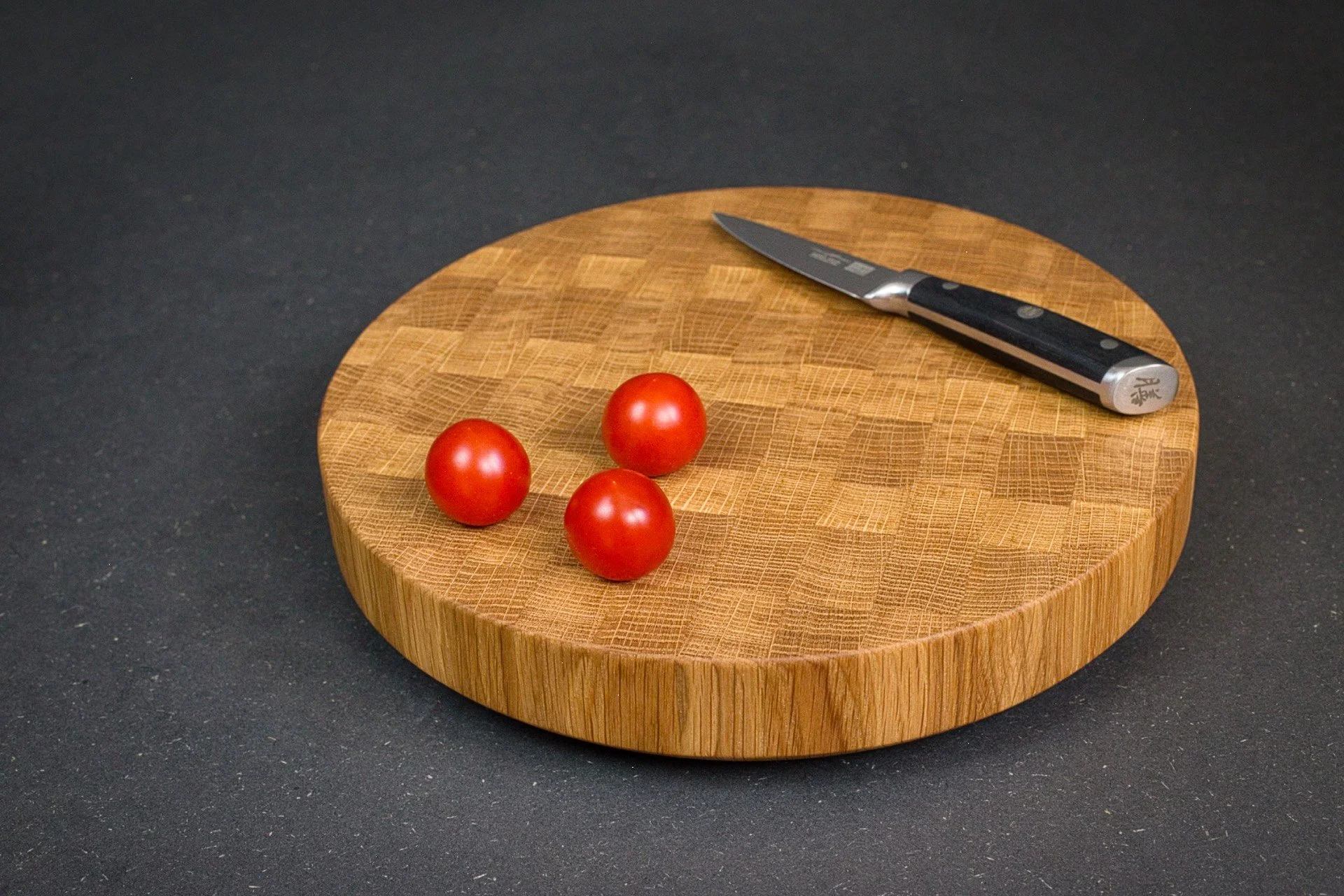 Planche à découper en bois de bout ronde avec tomates cerises et couteau - Atelier Samo - Dijon