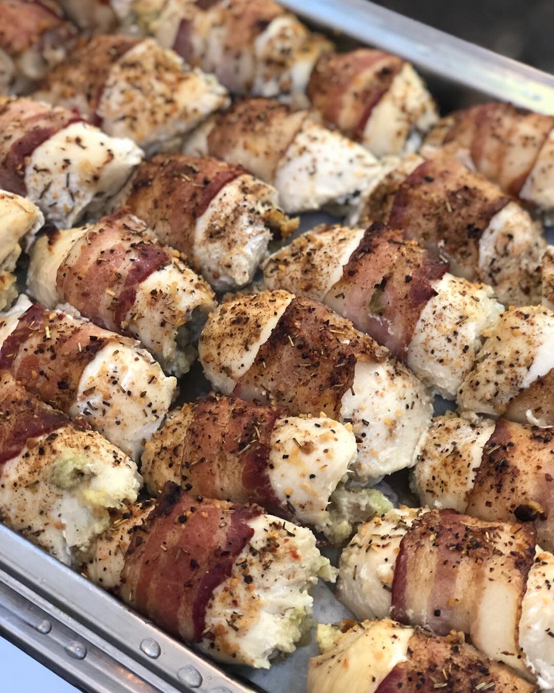 Bacon wrapped, apple cornbread stuffed chicken! Topped with a Parmesan Cream sauce.