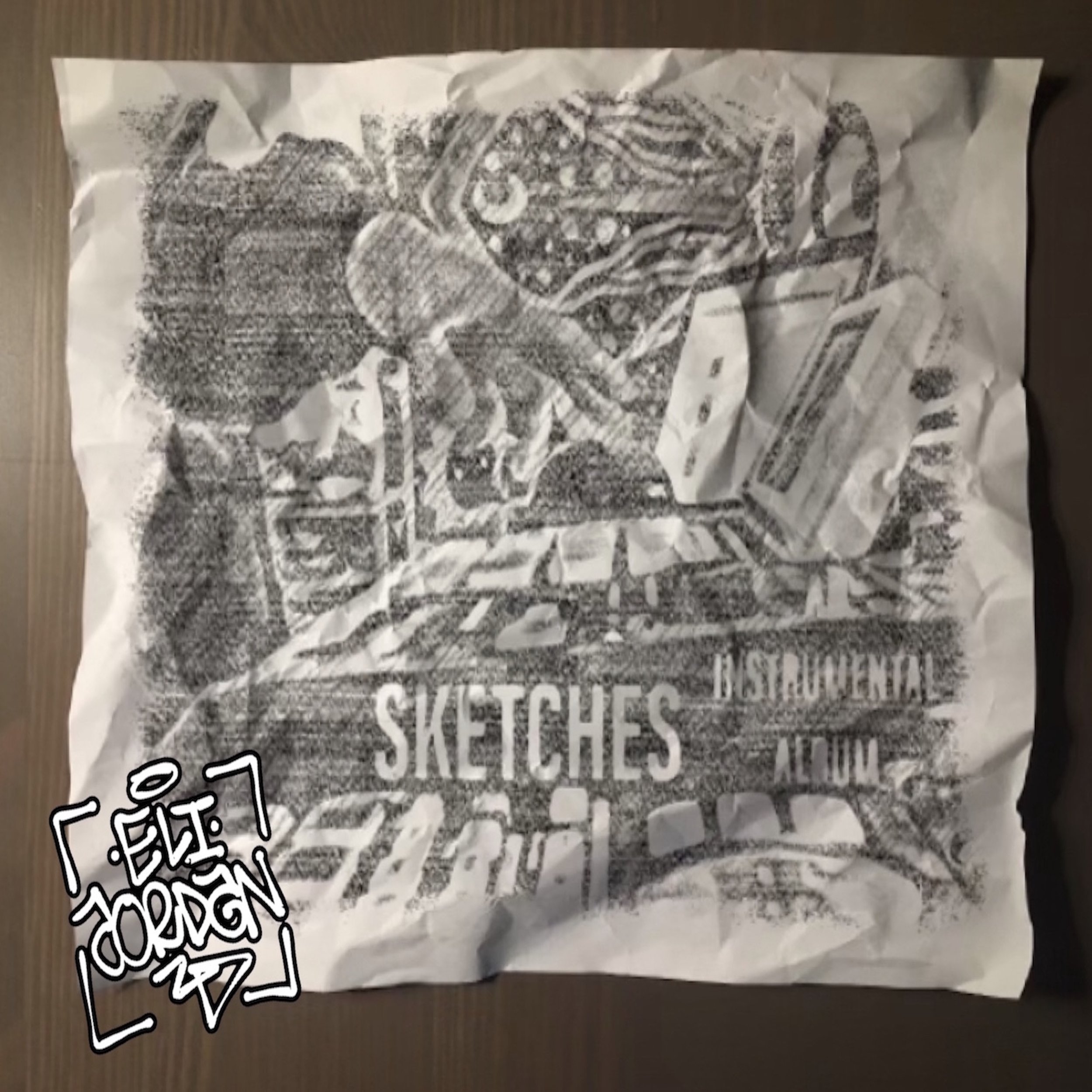A crumpled piece of paper with black and white printed design and handwritten notes.