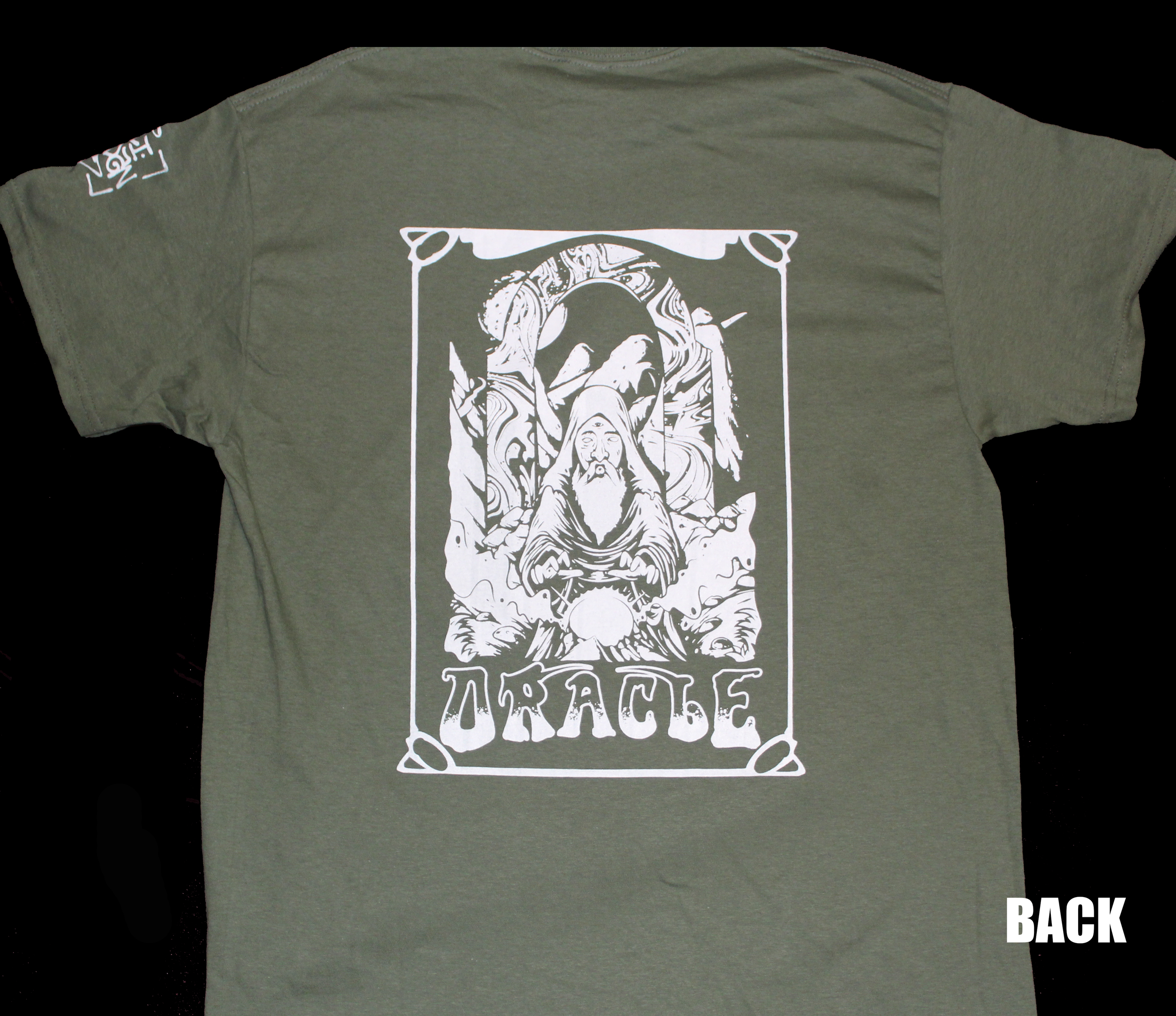 A green t-shirt with a graphic design of a religious figure at the center, enclosed in a rectangular frame. The figure has long hair and a beard, with hands raised. The word "BACK" is written in white text at the bottom right corner of the image.