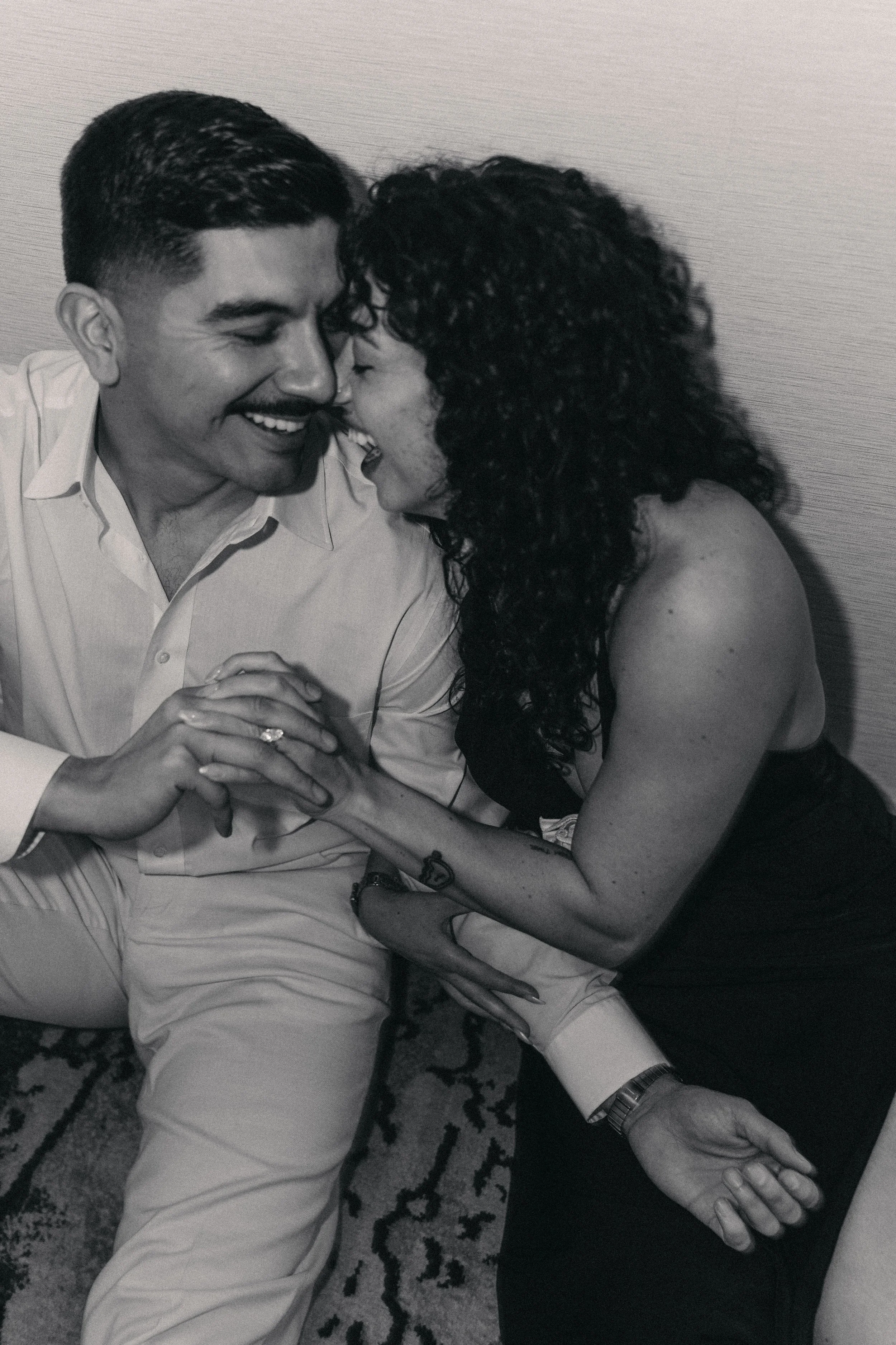 A black and white photo of a man and woman close together, smiling and touching hands, in an intimate moment. Engagement session, Waters Street. Tampa Fl. Romantic couple photos