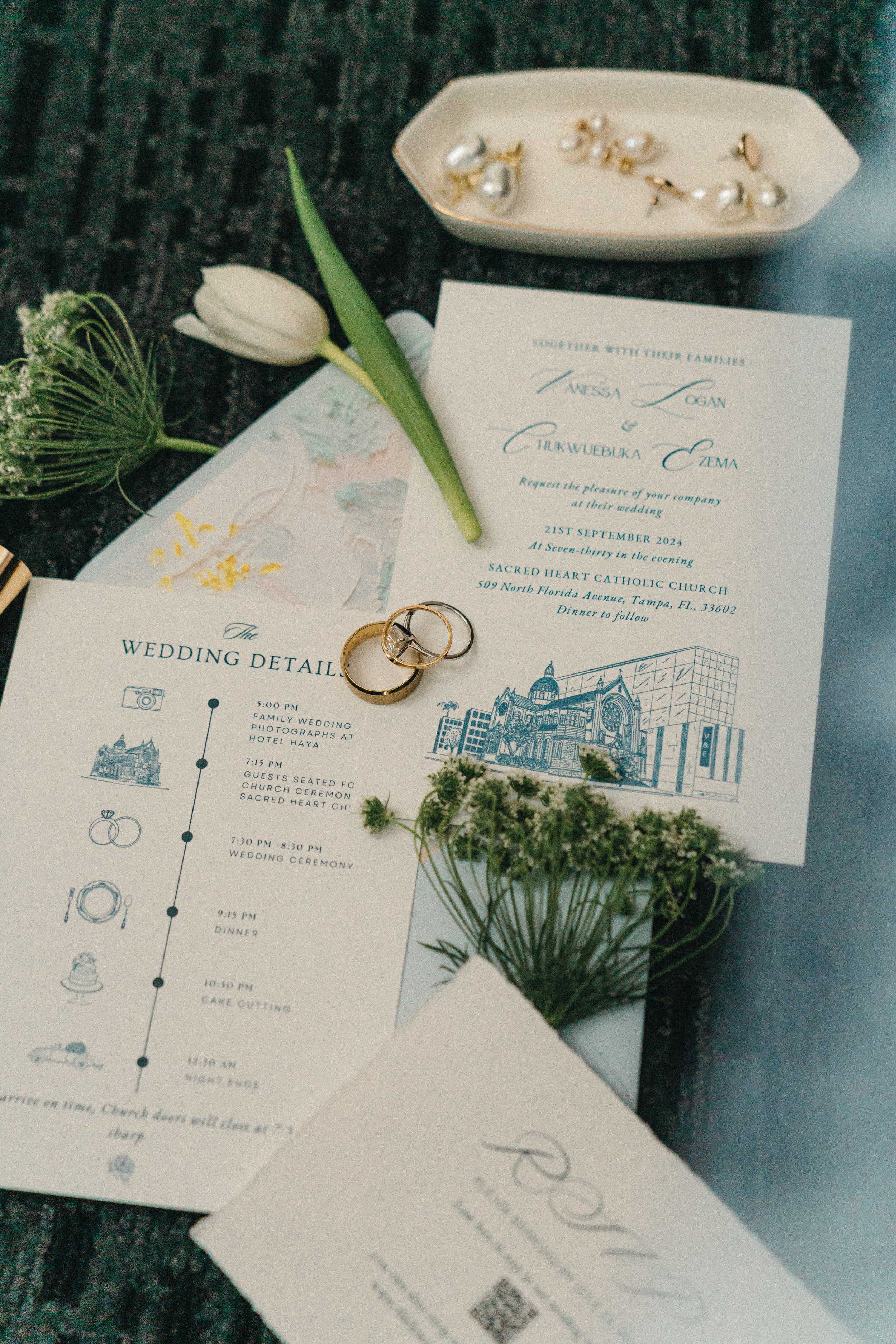 Wedding invitation, rings, flowers, and wedding details on a dark table. Wedding details, Flatlay photography, LIZAEVEPHOTO, high-end decor, wedding inspo, NY, TAMPA, Bi- Coastal.