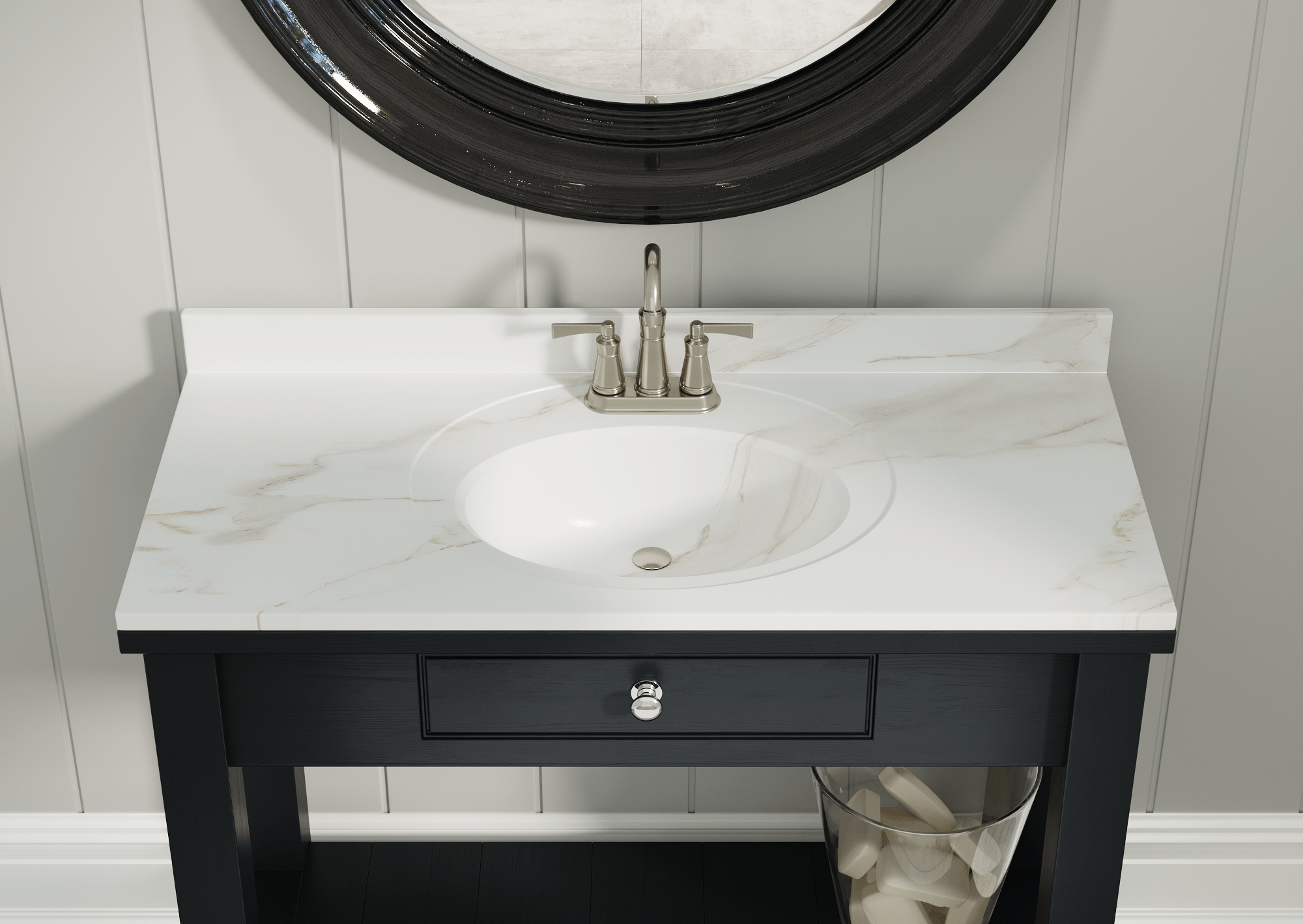 Bathroom vanity with white marble countertop, oval sink, and brushed nickel faucet, reflected in a large black-framed mirror, against gray paneled wall.