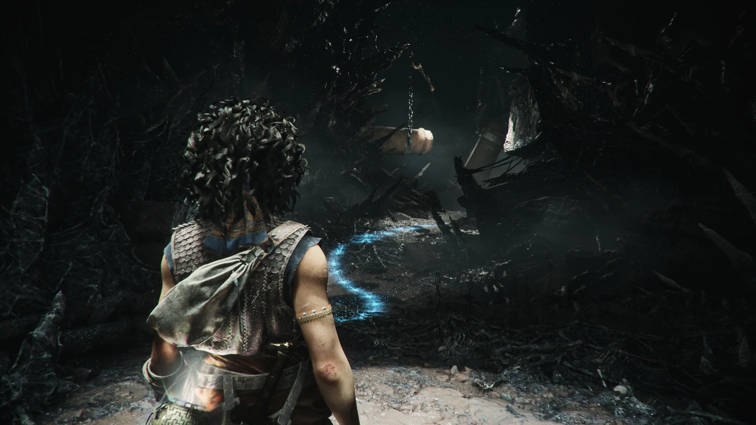 A glowing blue trail in a dark corridor in Resonance: A Plague Tale Legacy