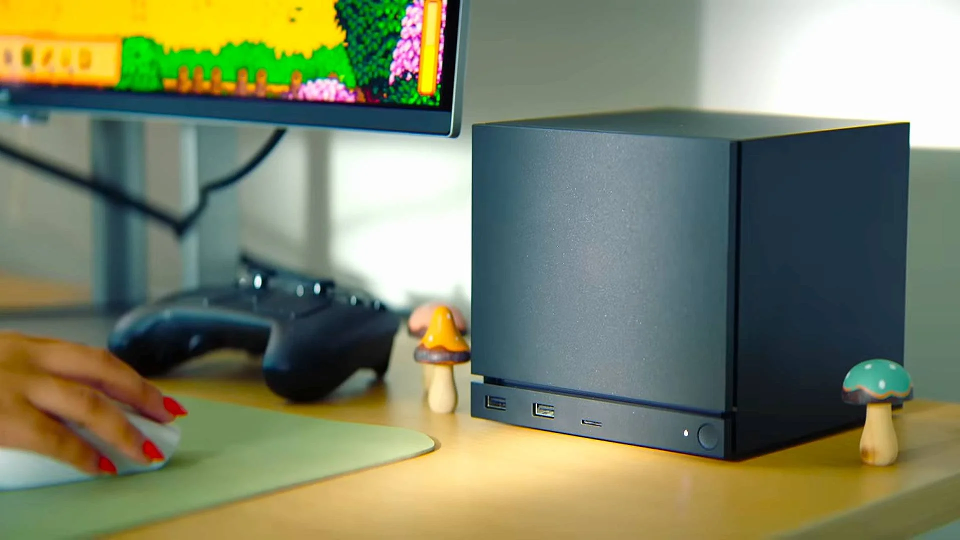 The Steam Machine set up on a desk top beside the Steam Controller