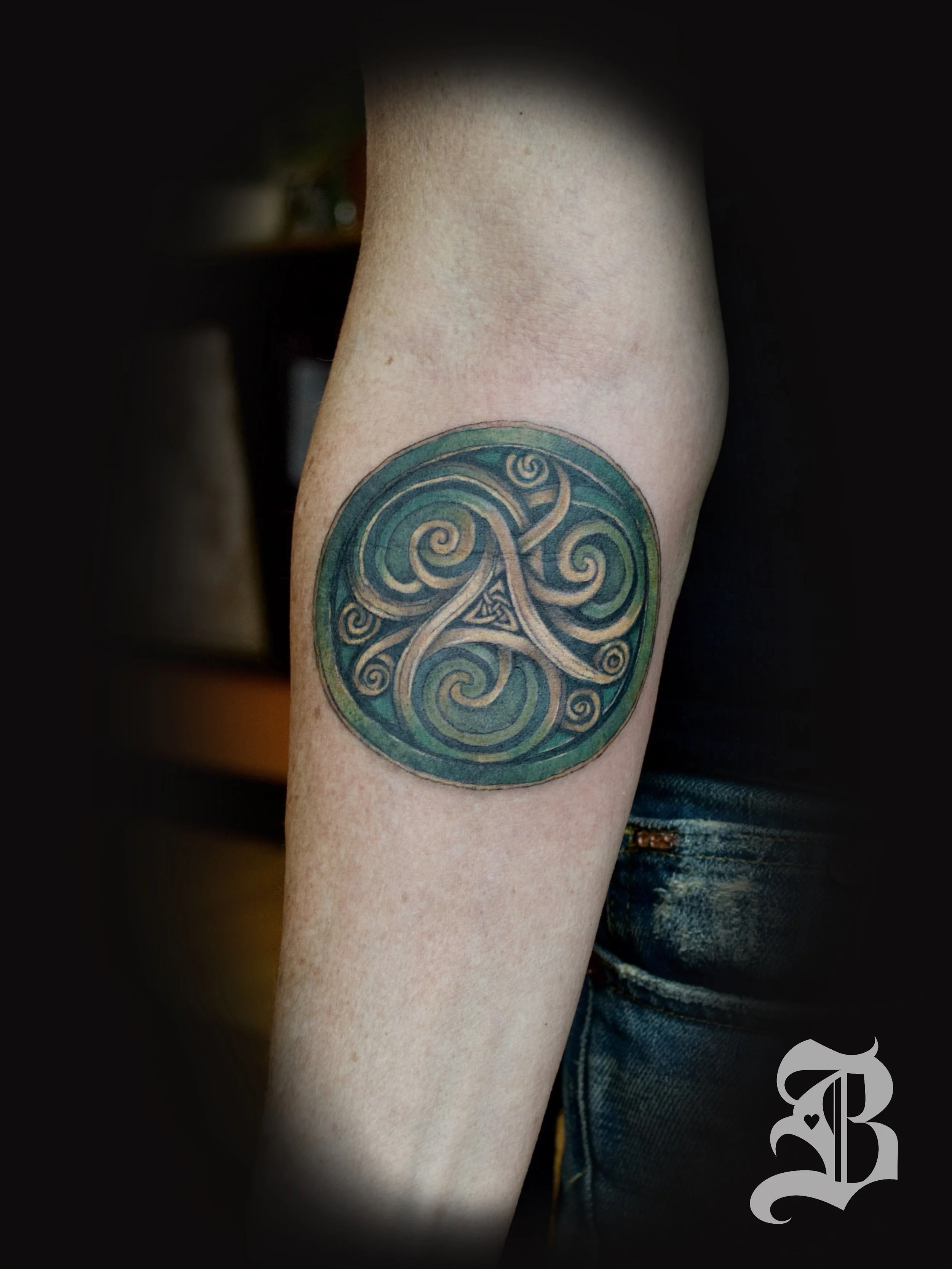 micro-realistic Celtic Irish triskele forearm tattoo.