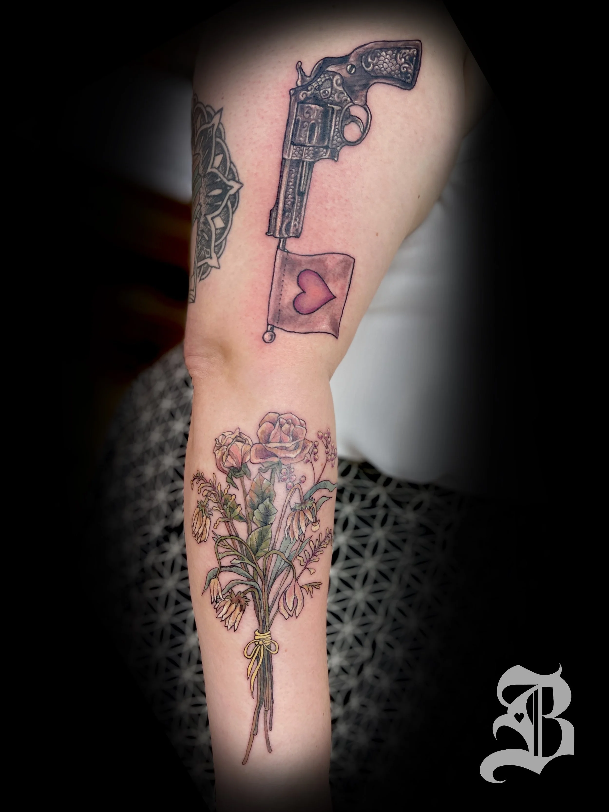 Black and gray decorative love gun and bouquet of dead flowers.