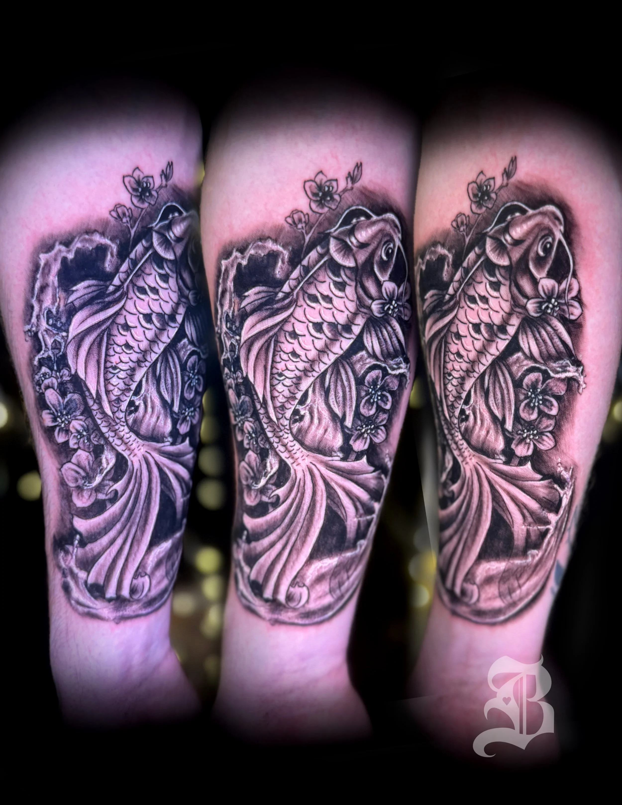Black and gray tattoo of a koi fish swimming among flowers on an arm by Binx inks..