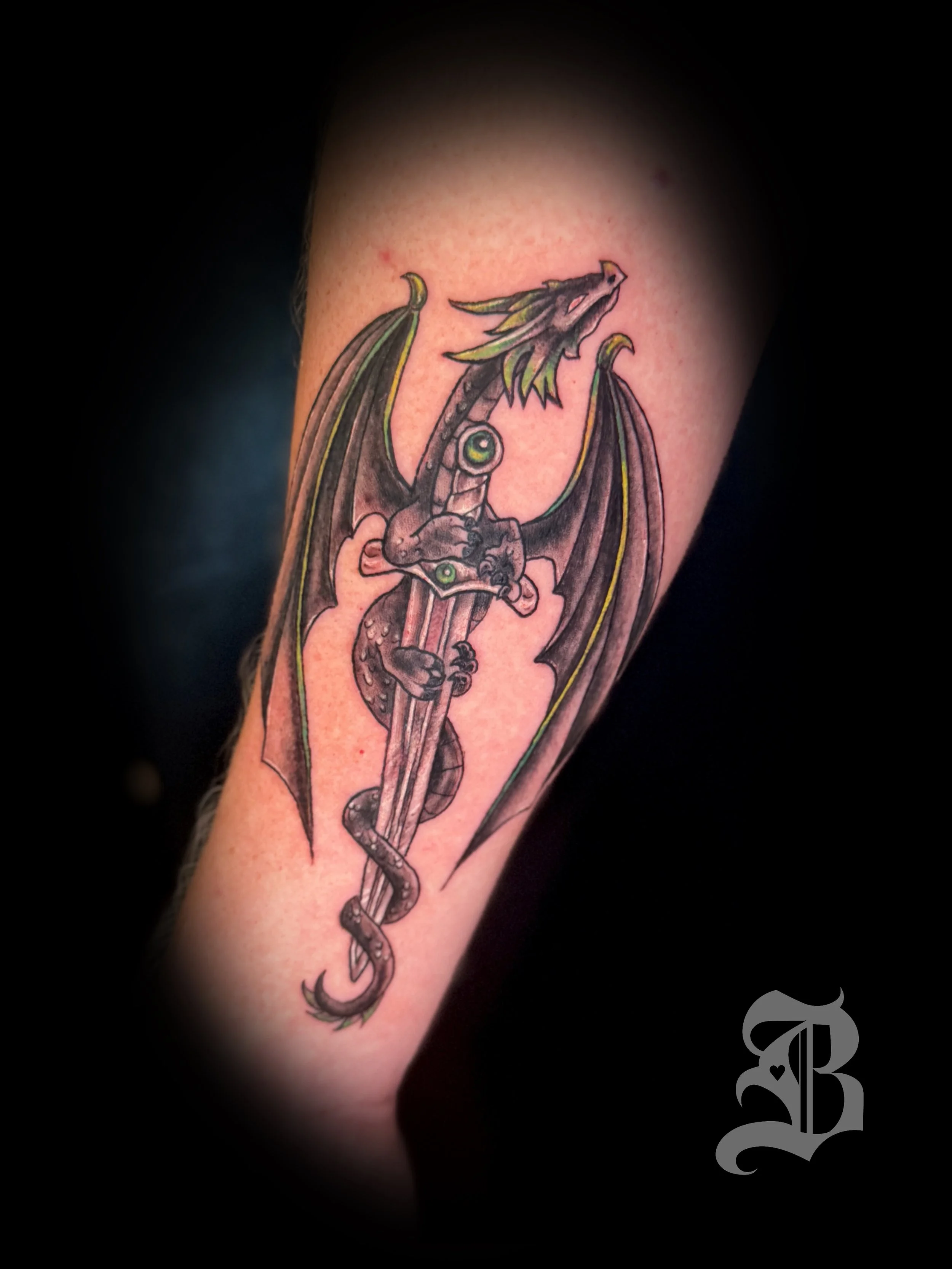 Illustrated dagger and dragon forearm tattoo.