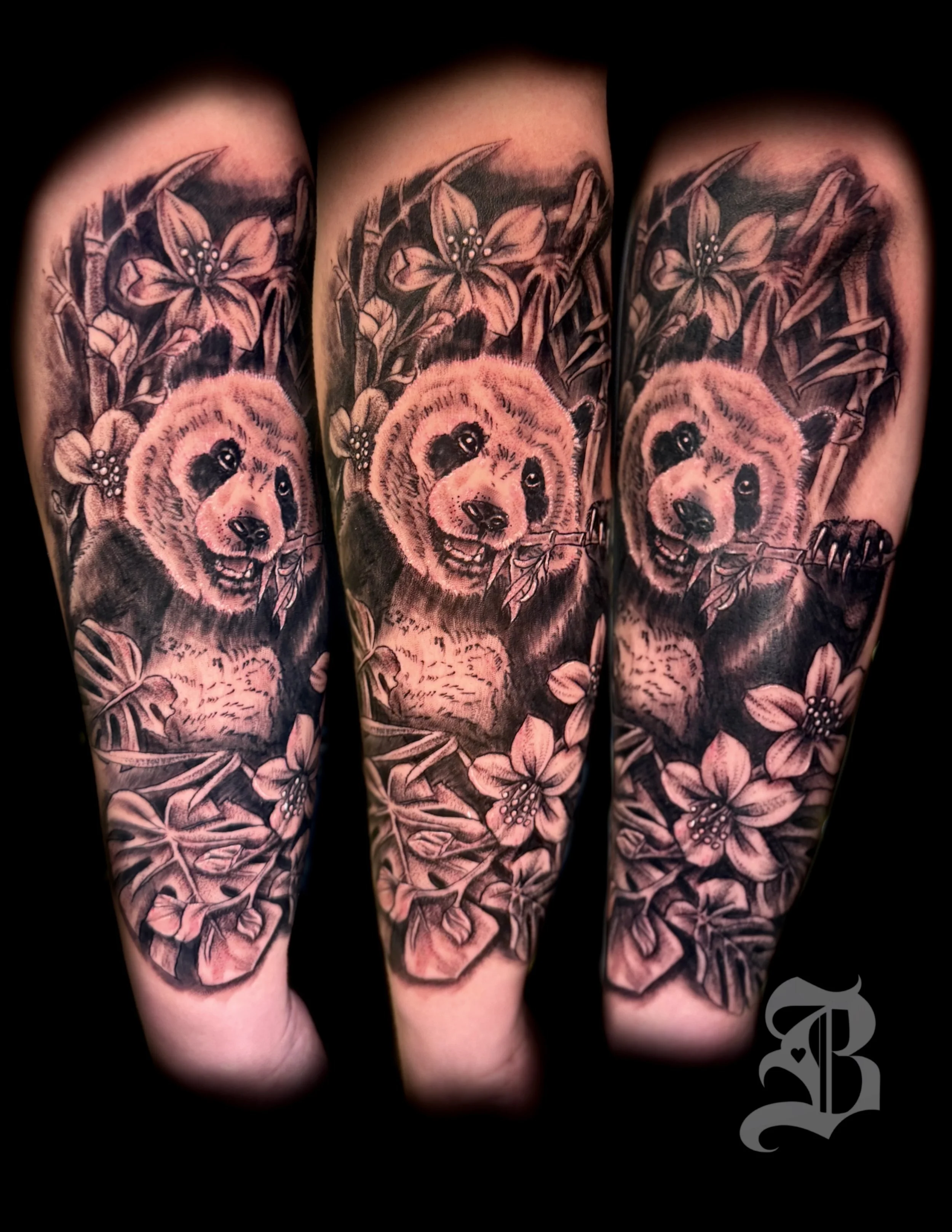 Black and gray tattoo of a bear cub surrounded by flowers and foliage on a person's arm by Binx inks..