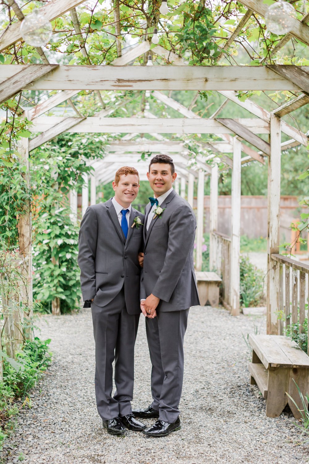  Two grooms pose under an arbor. 