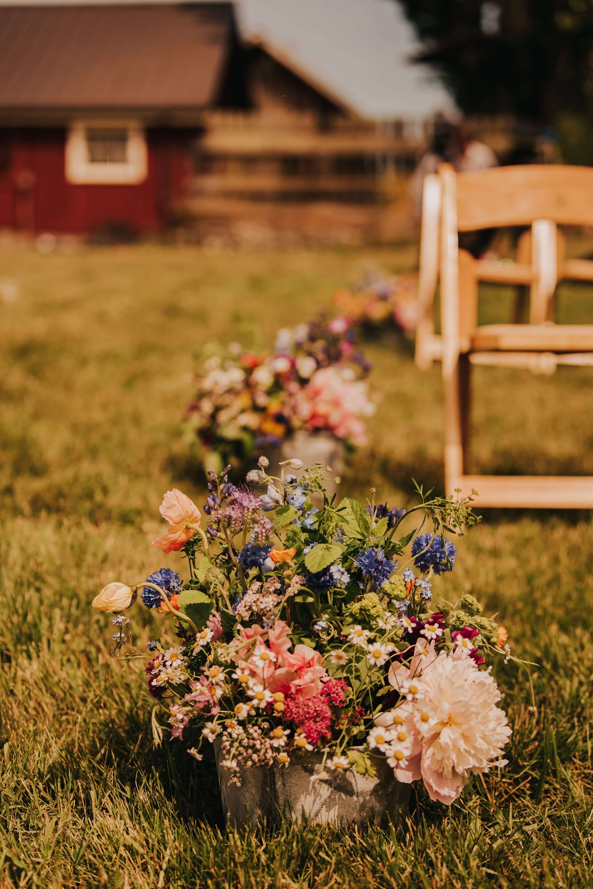  Colorful floral arrangements line a wedding ceremony aisle. 