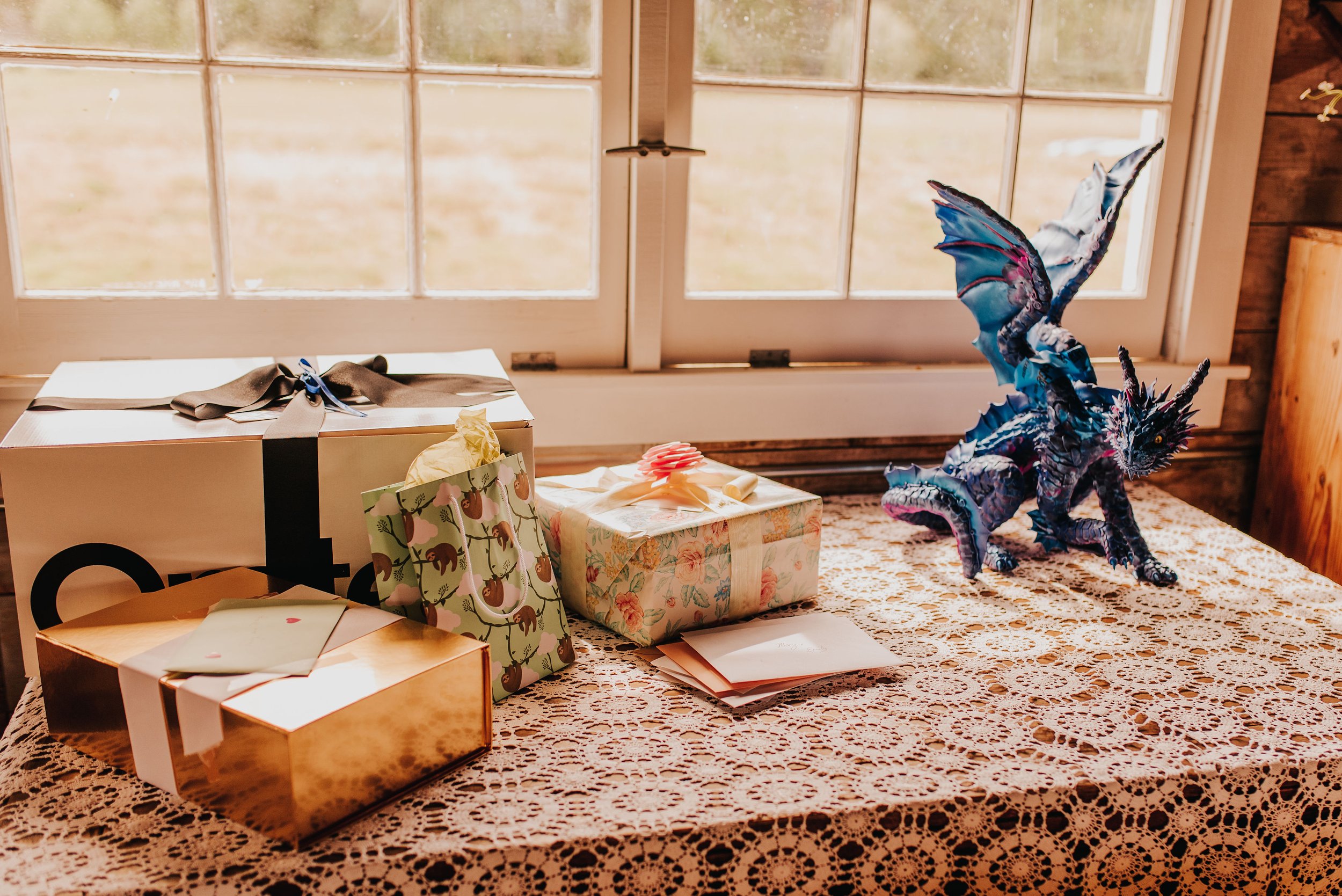  A gift table with a lace tablecloth also features a blue dragon sculpture. 