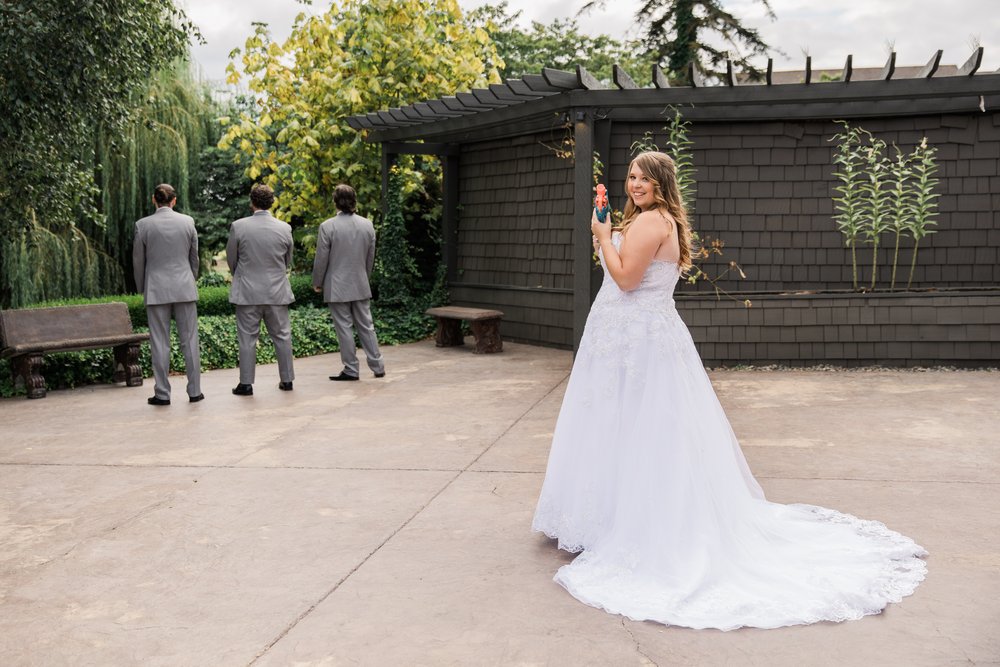  A bride prepares to prank her brothers during a “first look” moment by shooting them with a nerf gun 