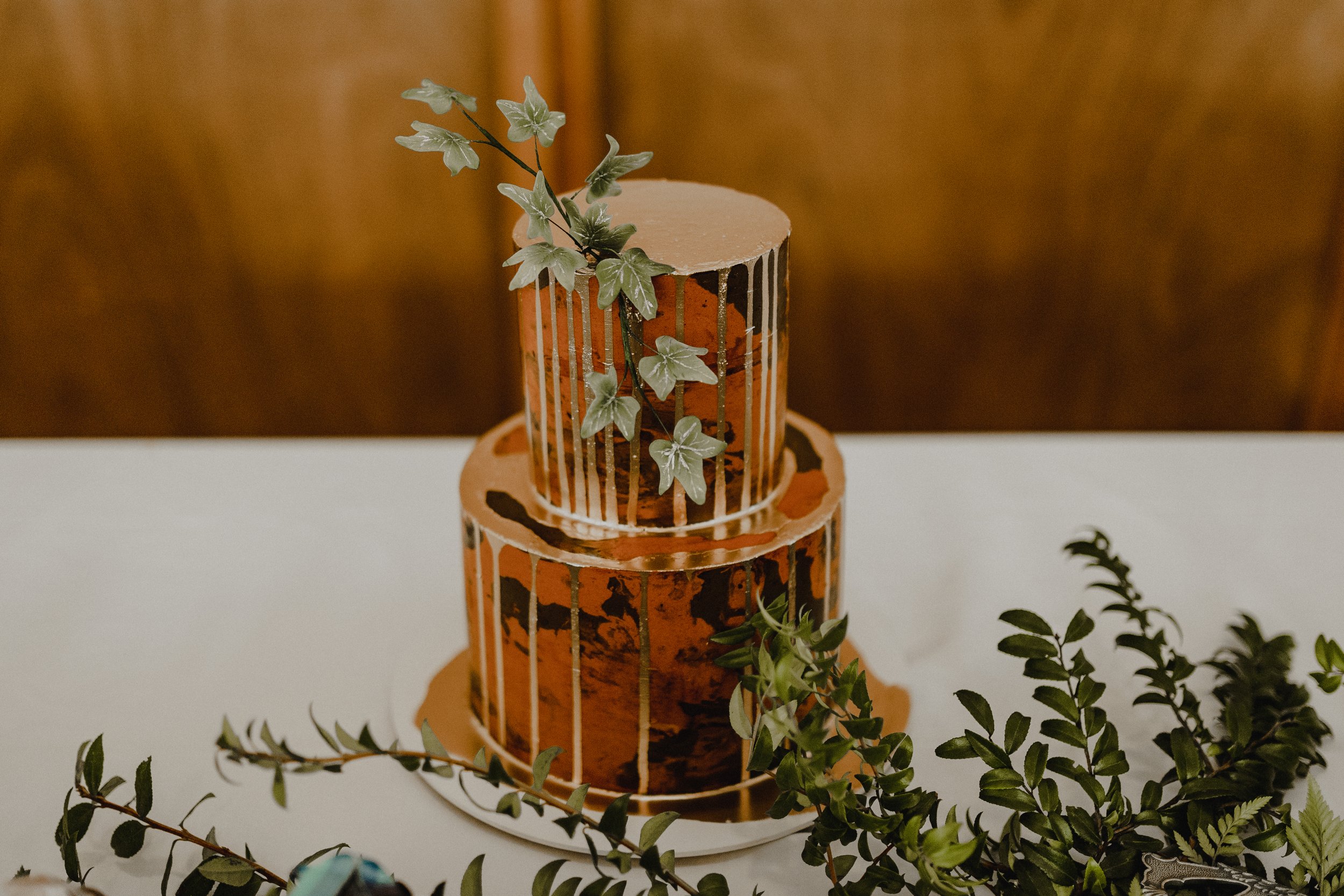  A red and black marbled wedding cake is dripping with gold and features edible leaves of Lothlorien. 