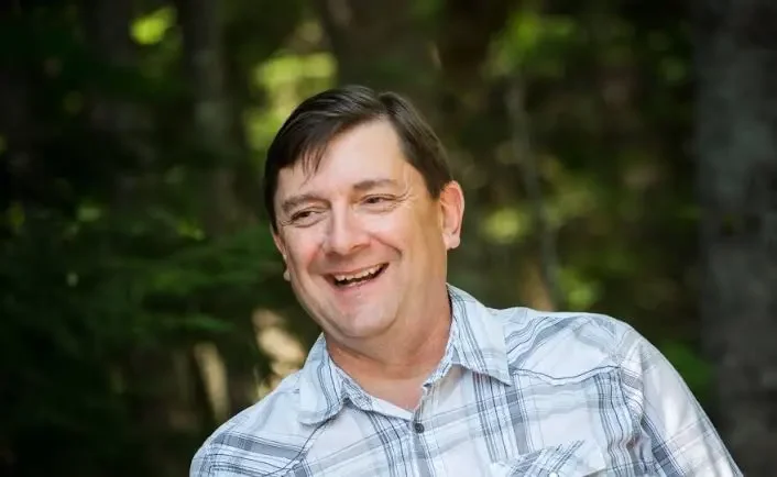 Troy Jackson smiling with woodsy background