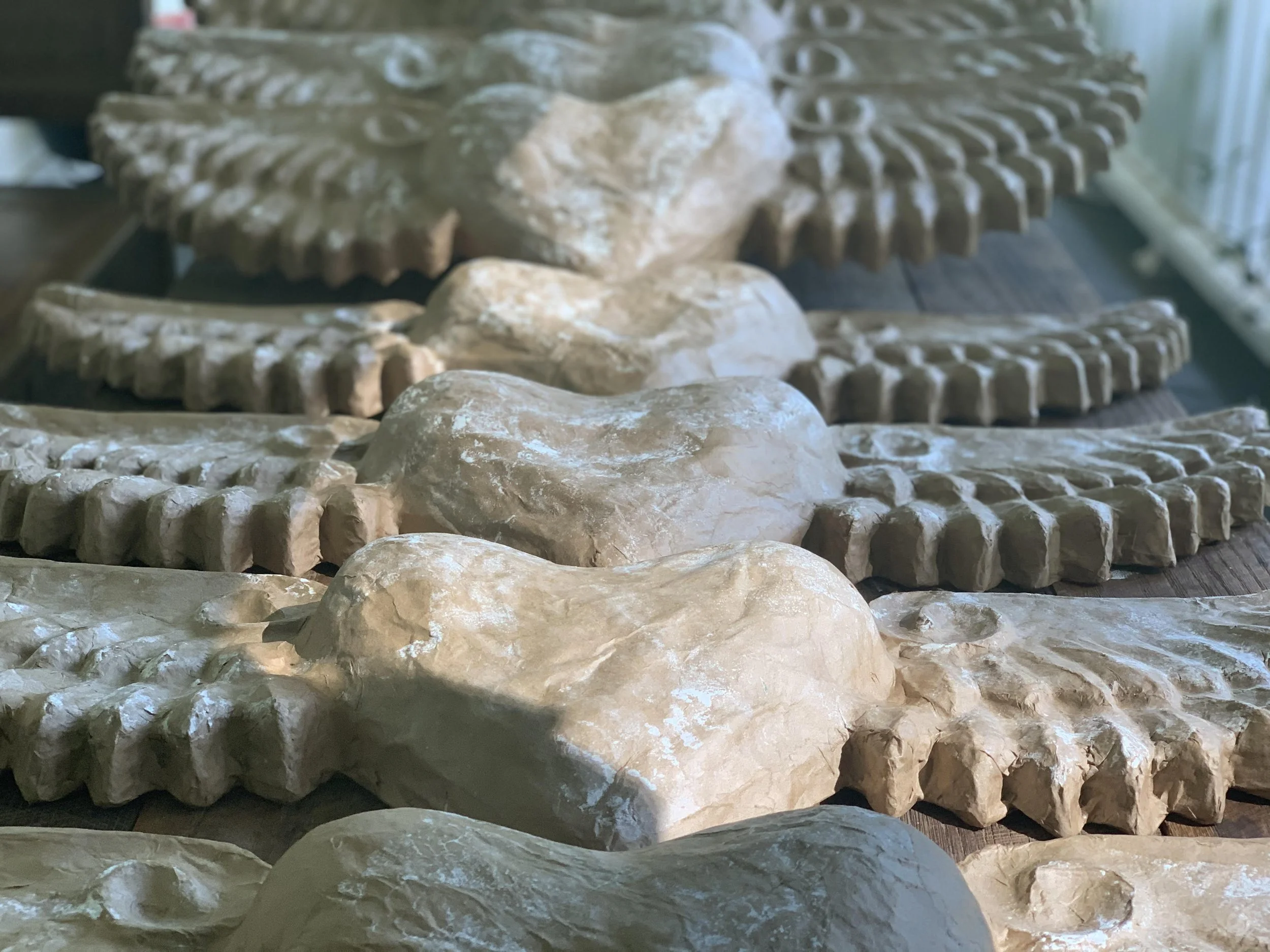 Detail of winged heart sculptures that are ready to paint