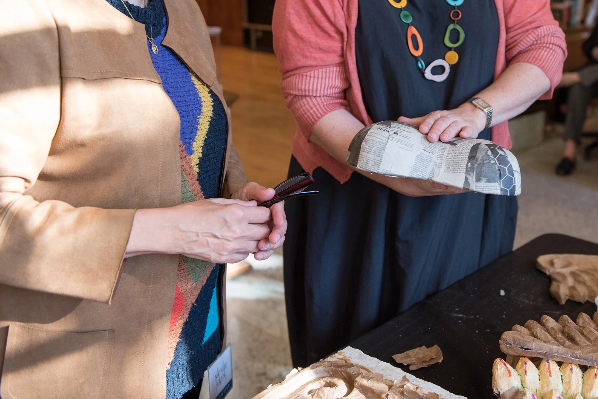 Two people touching the materials used in the installation