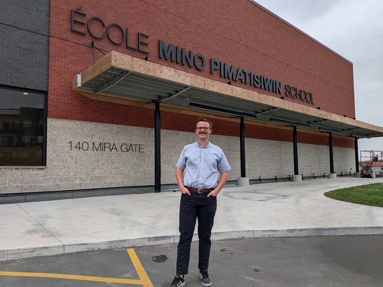 Evan Krosney standing outside of Seven Oaks' newest school, École Mino Pimatisiwin