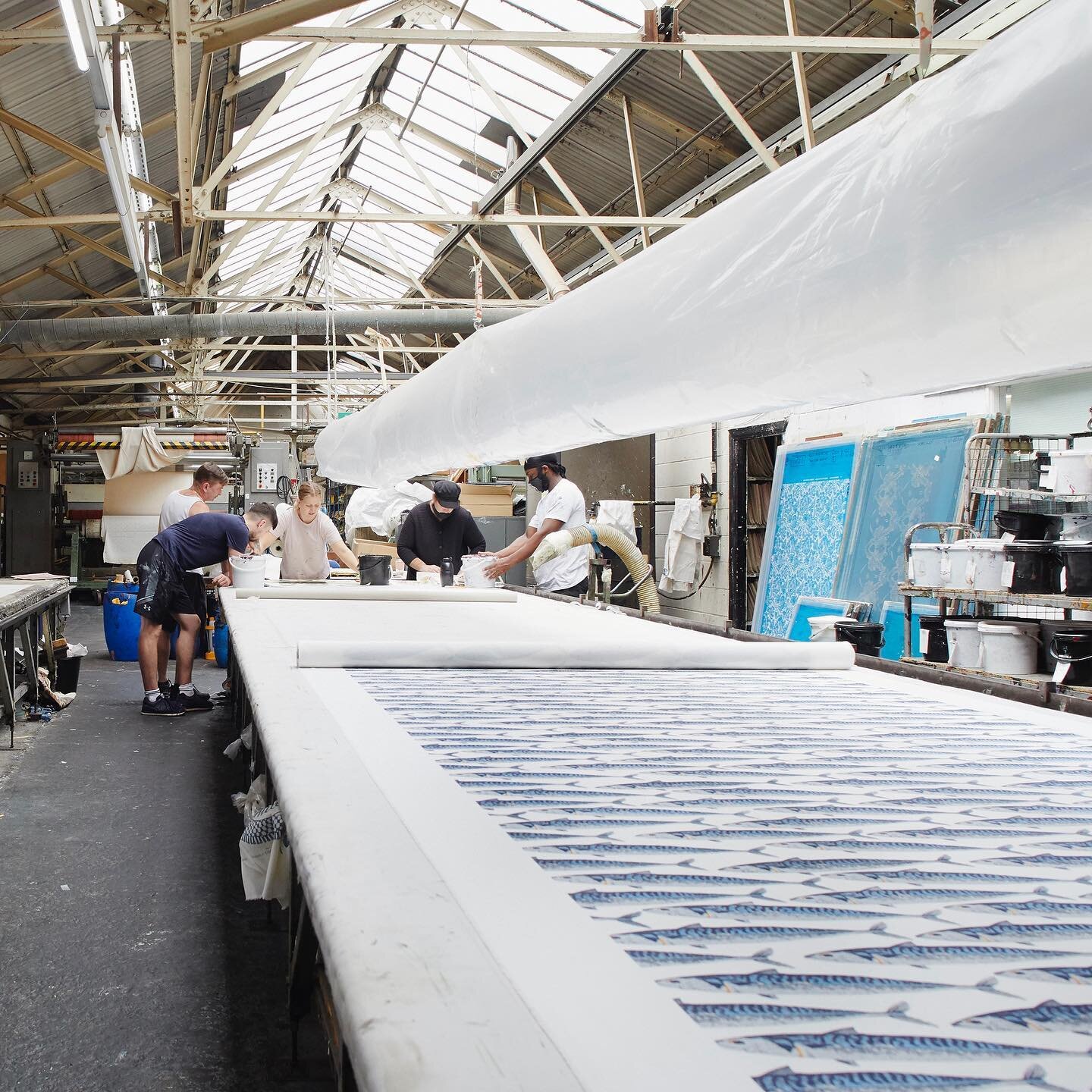 Inside Ivo Prints&rsquo; 37,000 sq ft factory in Southall that includes three 53 metre-long manual screen-printing tables. The 45-strong team produce wallpaper and printed textiles, as they have since 1963. The image is by @carmelkingphoto from the b