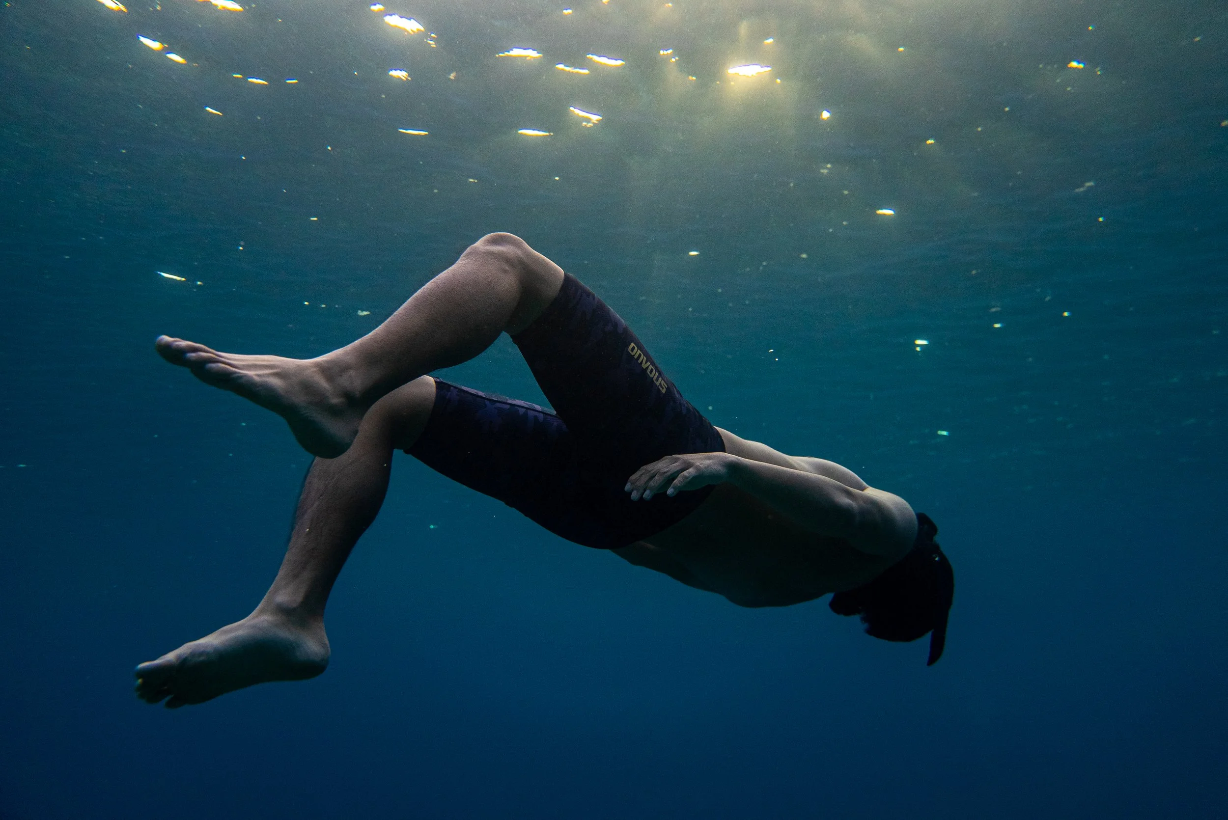 Product photography featuring a model suspended underwater. 