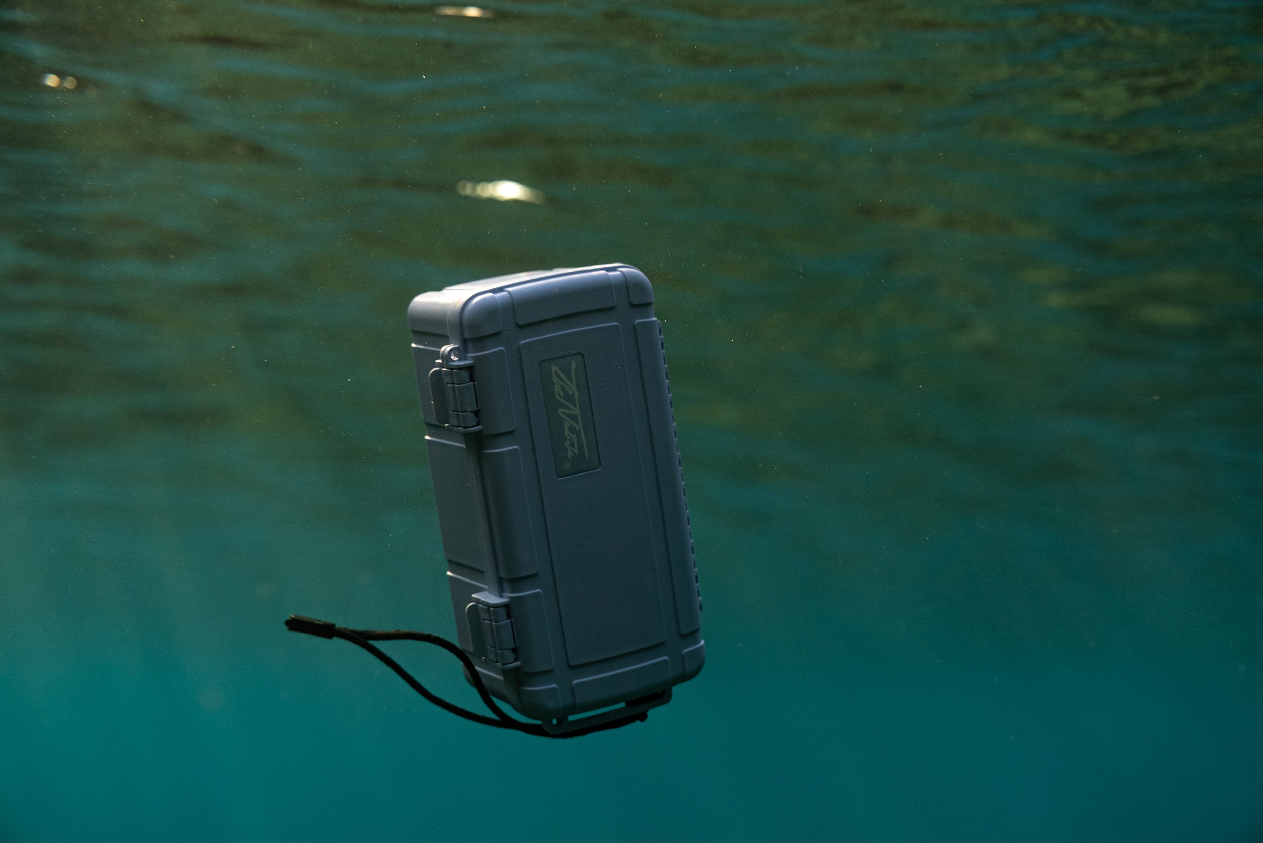A floating waterproof case suspended in water.