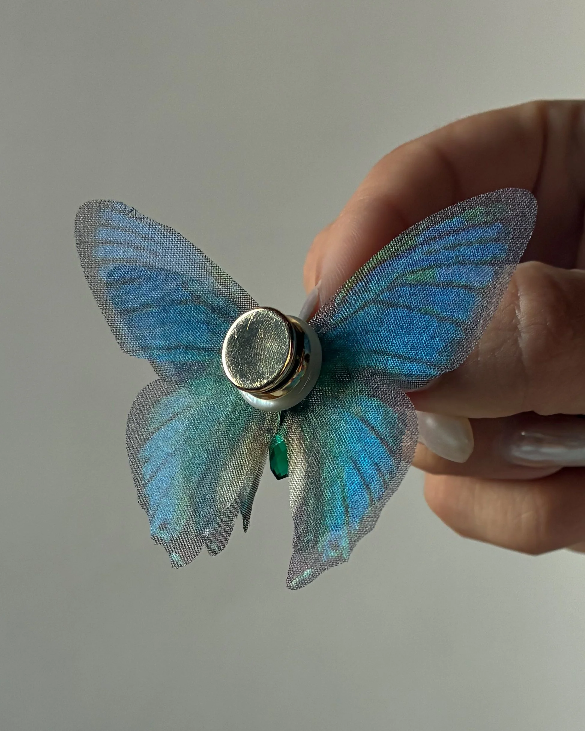 The back of a 3-layered blue butterfly magnet weight for a wedding veil