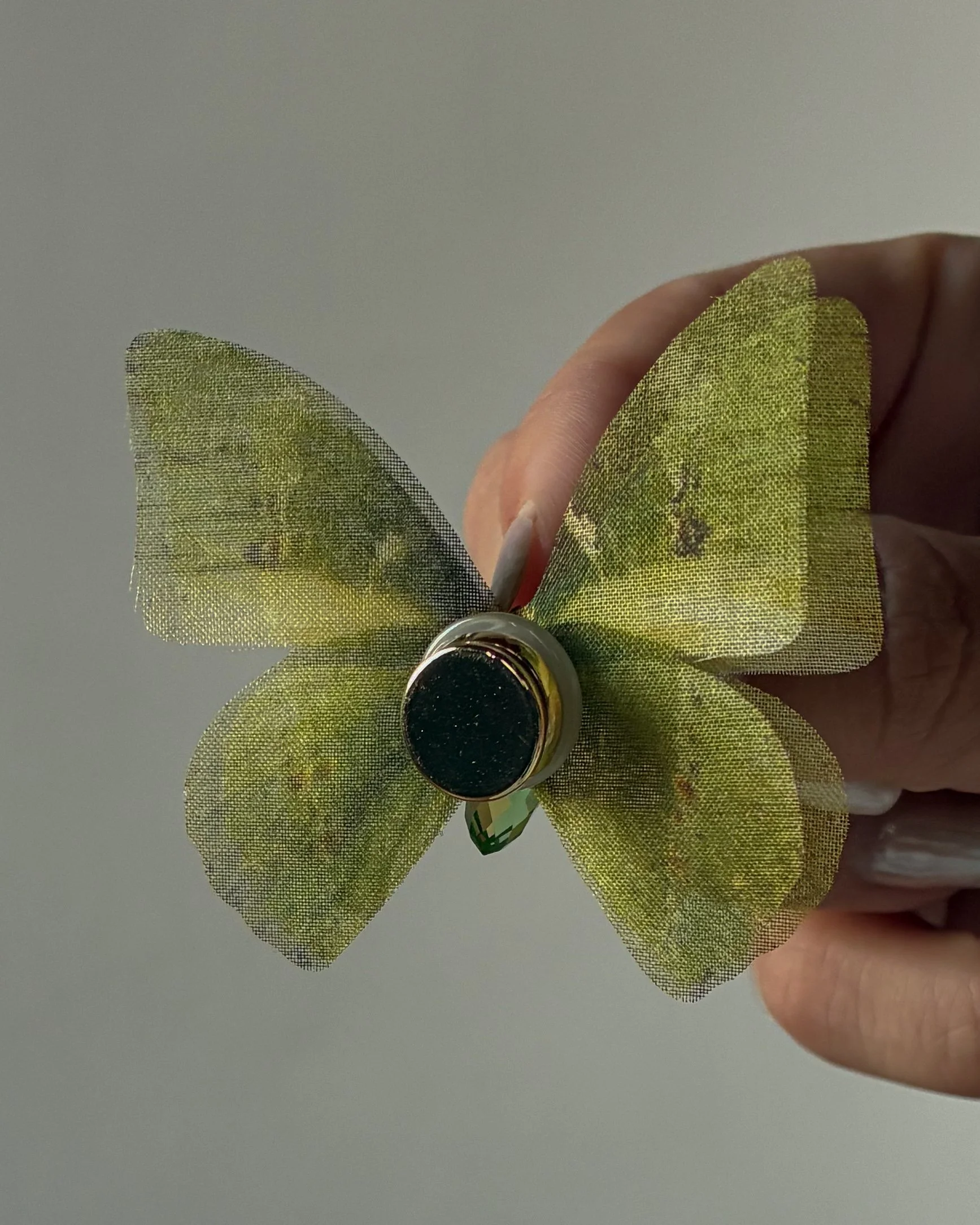 A 3-layered green silk organza wedding butterfly veil weight with a magnet