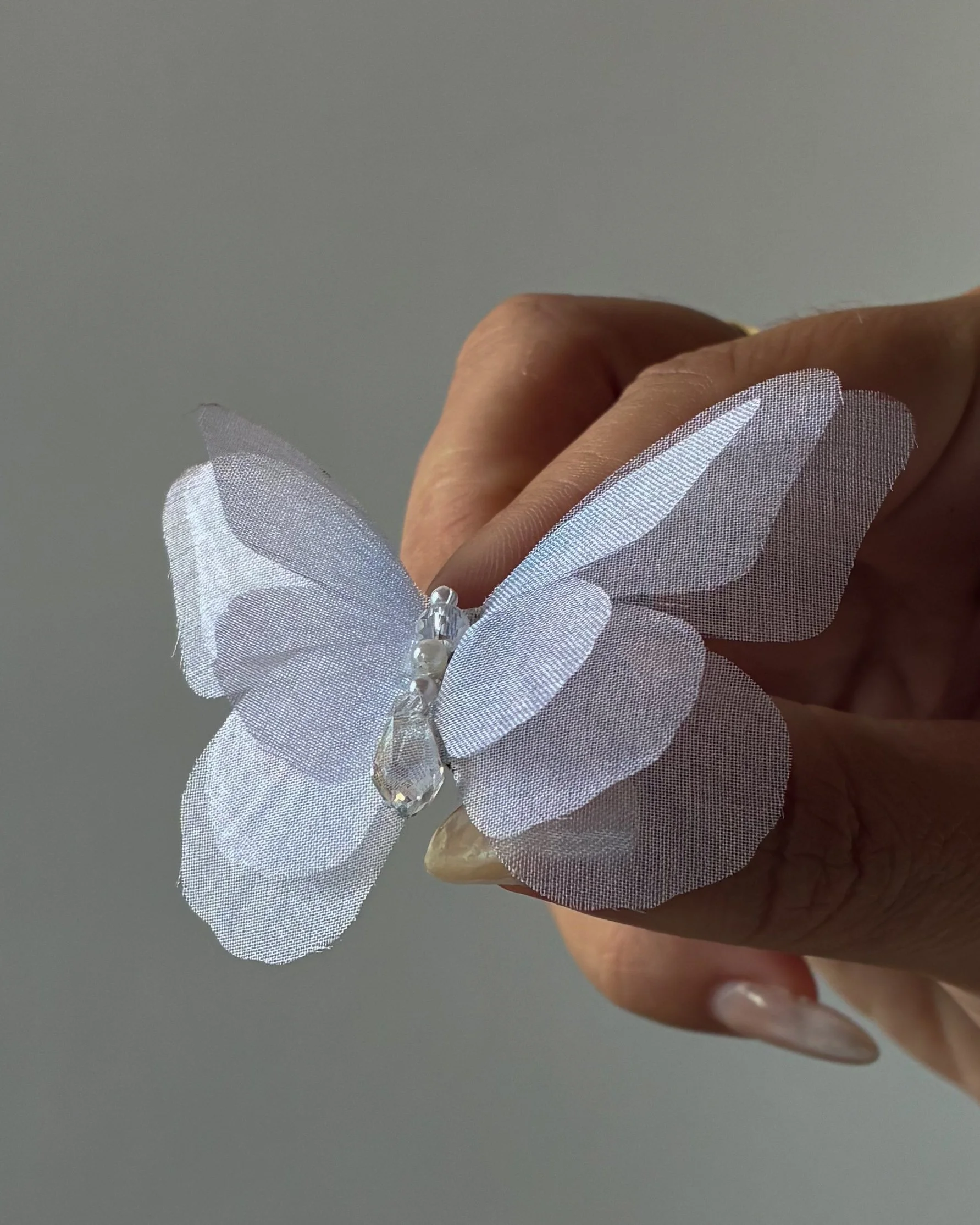White silk three-layer butterfly bridal veil weight with a magnetic backing and glass droplet detail.