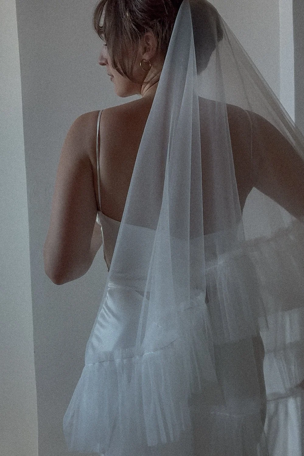 a bride wearing a white bridal veil with a blusher and a gathered edge